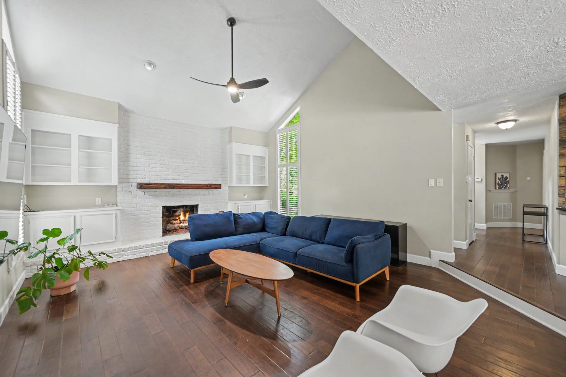 2314 Chestnut Oak Place, The Woodlands, TX 77380 The white painted brick fireplace, natural wood mantel and surrounding built-ins for display and storage create a warm focal point in the living room.