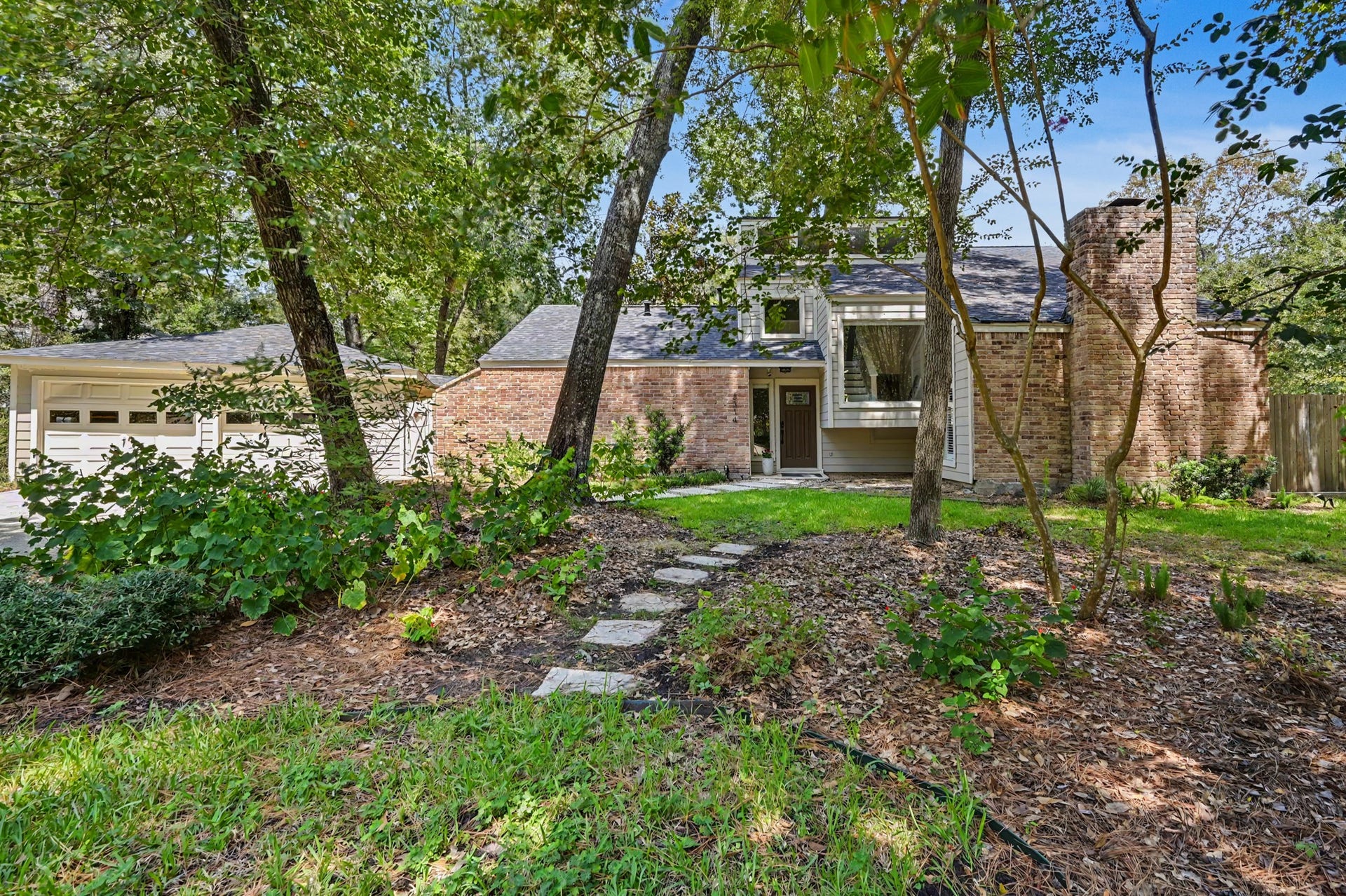 2314 Chestnut Oak Place, The Woodlands, TX 77380 A welcoming first impression with a tree-lined front yard and direct access to the pathway leading toward the greenbelt and Sawmill Park.
