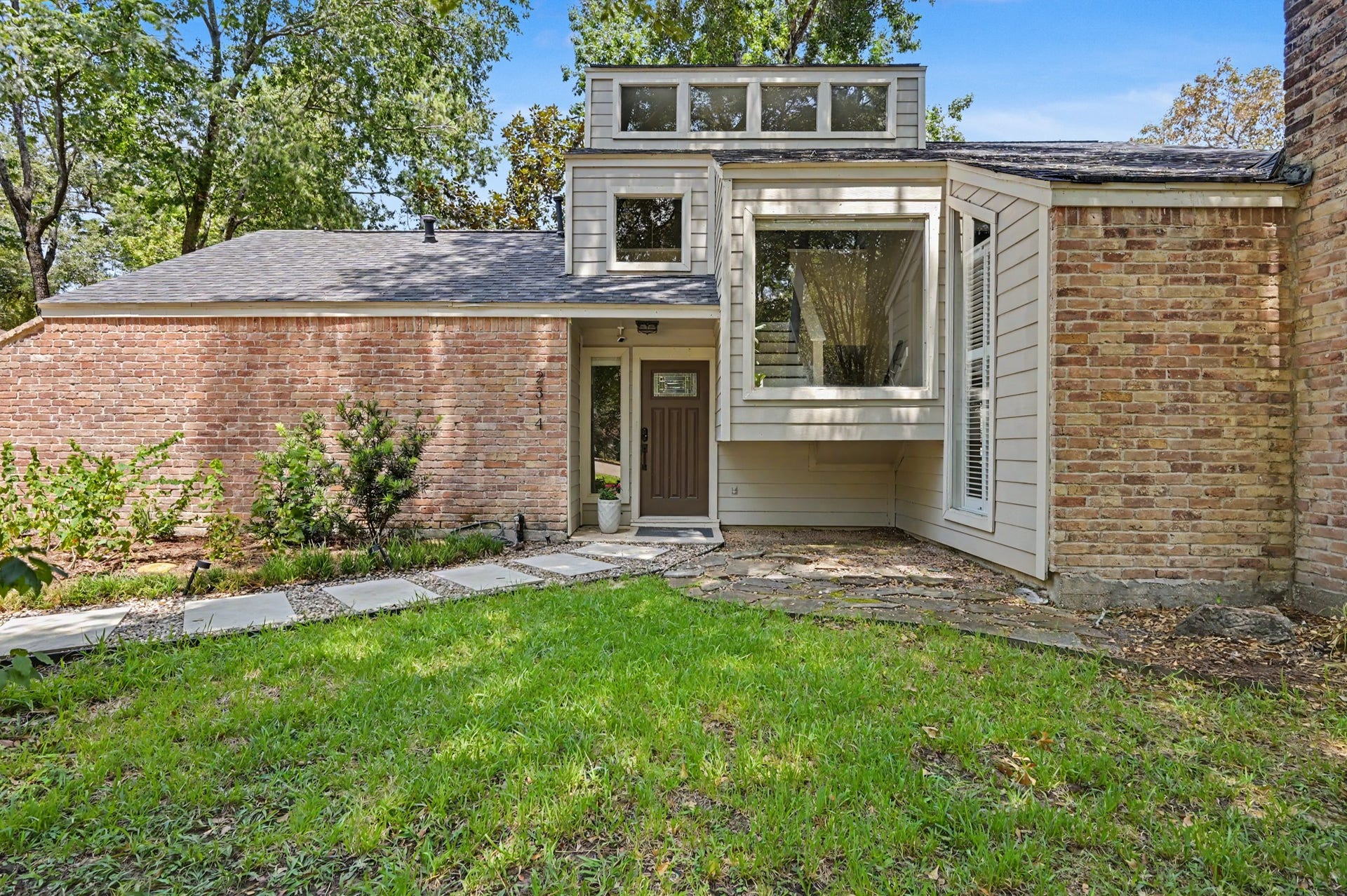 2314 Chestnut Oak Place, The Woodlands, TX 77380 Inviting front entry with distinctive window detail that brings natural light to the unique interior stair landing.