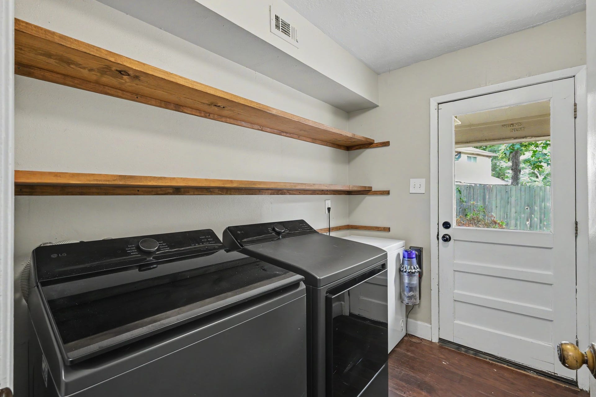 2314 Chestnut Oak Place, The Woodlands, TX 77380 The laundry room offers open shelving for storage and convenient access to the backyard and breezeway to the two car garage.