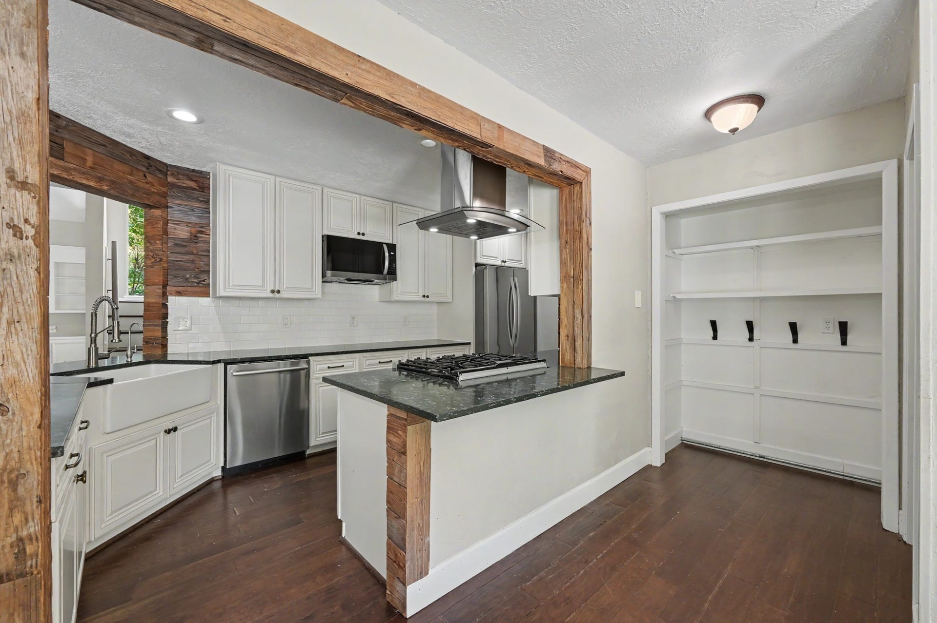 2314 Chestnut Oak Place, The Woodlands, TX 77380 The gas cooking area and stainless steel vent hood overlook the adjoining breakfast room, where a large window brings in natural light and backyard views.