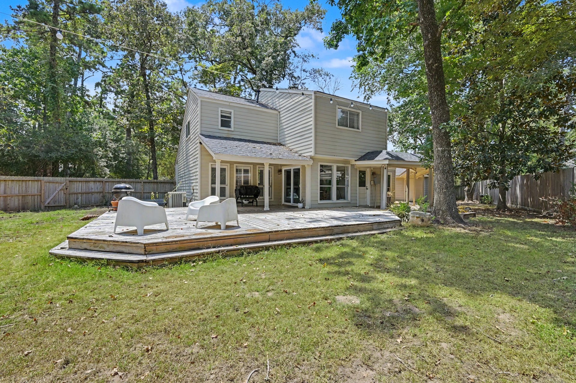 2314 Chestnut Oak Place, The Woodlands, TX 77380 Rear exterior view overlooking the private, secluded backyard with a new cedar fence and convenient breezeway leading to the detached two car garage.