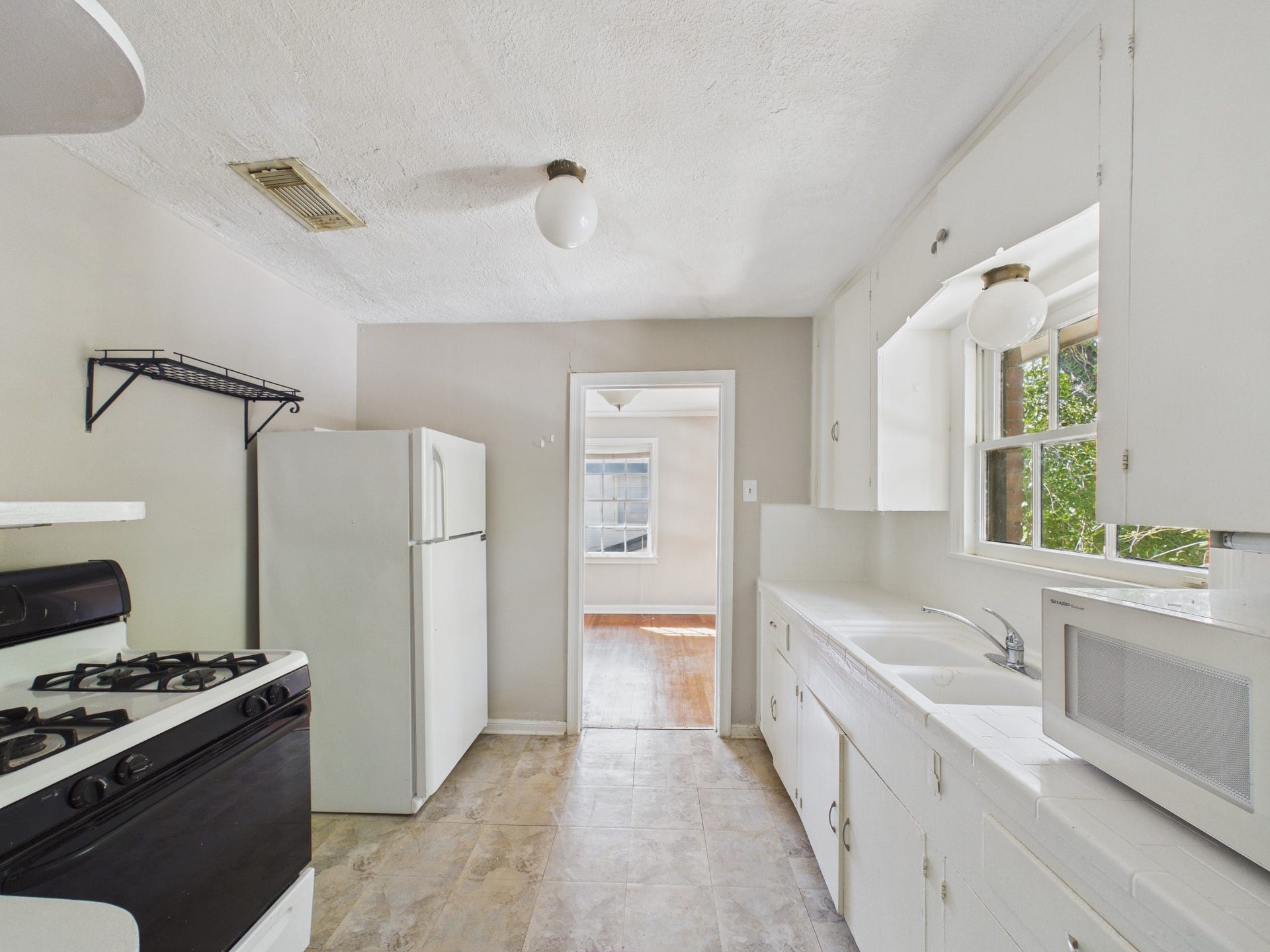 4502 Larch Lane, Bellaire, TX 77401 Kitchen with Tile Counters, White Refrigerator & Gas Range
