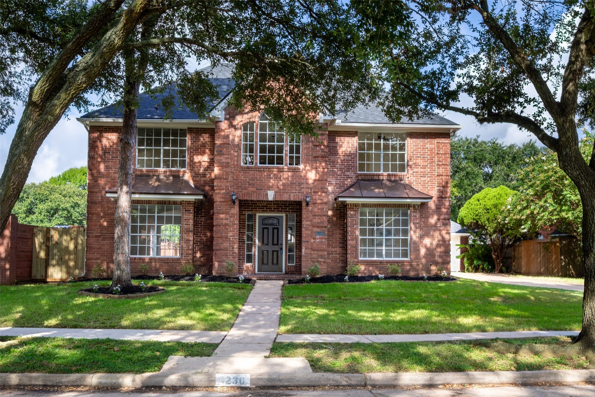 Welcoming front door, and a well-maintained lawn with mature trees. It's located in a peaceful neighborhood, offering both privacy and a sense of community.