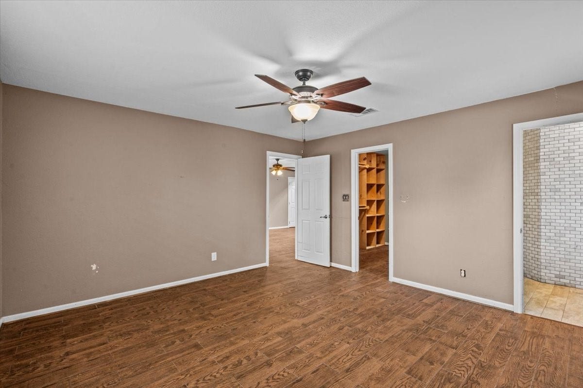 7228 Avenue R, Santa Fe, TX 77510 Primary bedroom with door to en-suite bathroom and walk in closet with built in shelving.