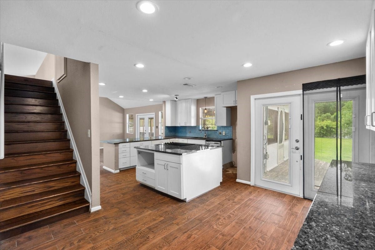 7228 Avenue R, Santa Fe, TX 77510 Expansive kitchen with second set of french doors onto back porch and stairs leading up to game room.