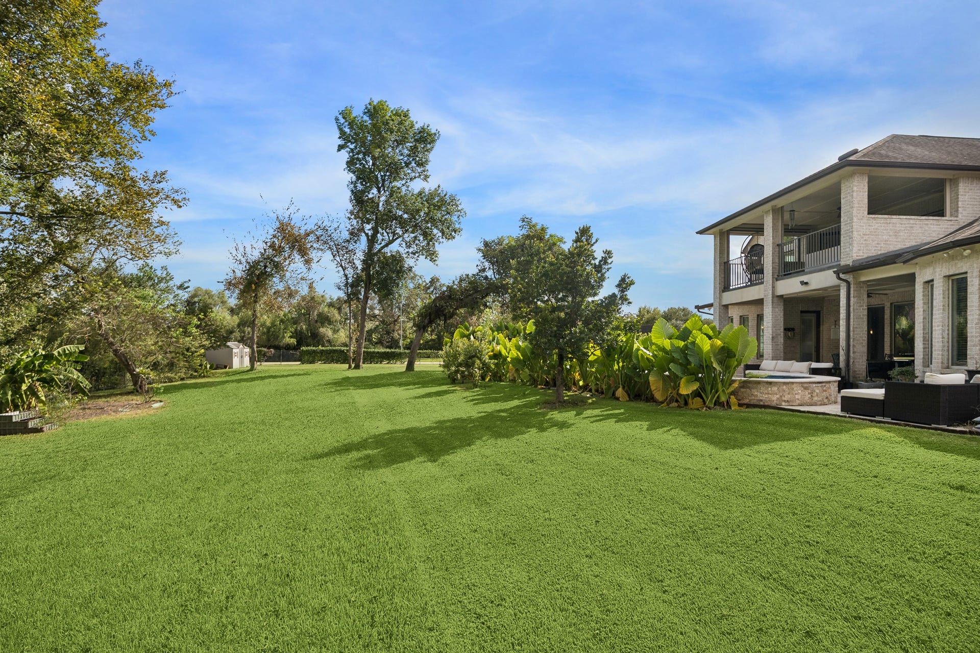 5018 Southampton Road, Missouri City, TX 77459 Expansive backyard with lush greenery and a spacious patio perfect for outdoor entertaining.