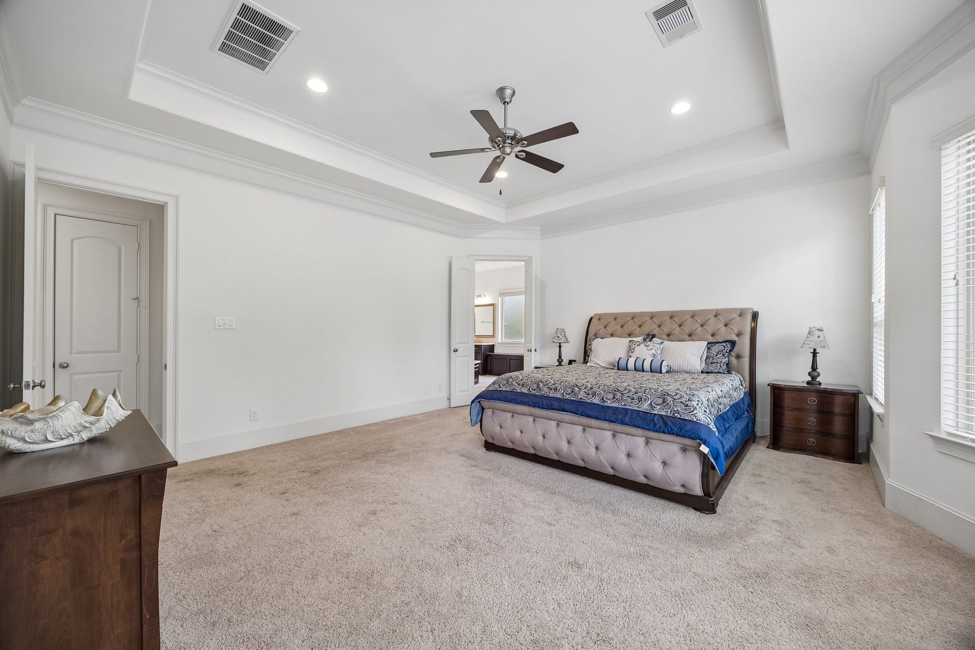 5018 Southampton Road, Missouri City, TX 77459 This spacious Primary bedroom with a elegant tray ceiling, plush carpeting, and abundant natural light and amazing views of the backyard pool area is the perfect place to unwind.