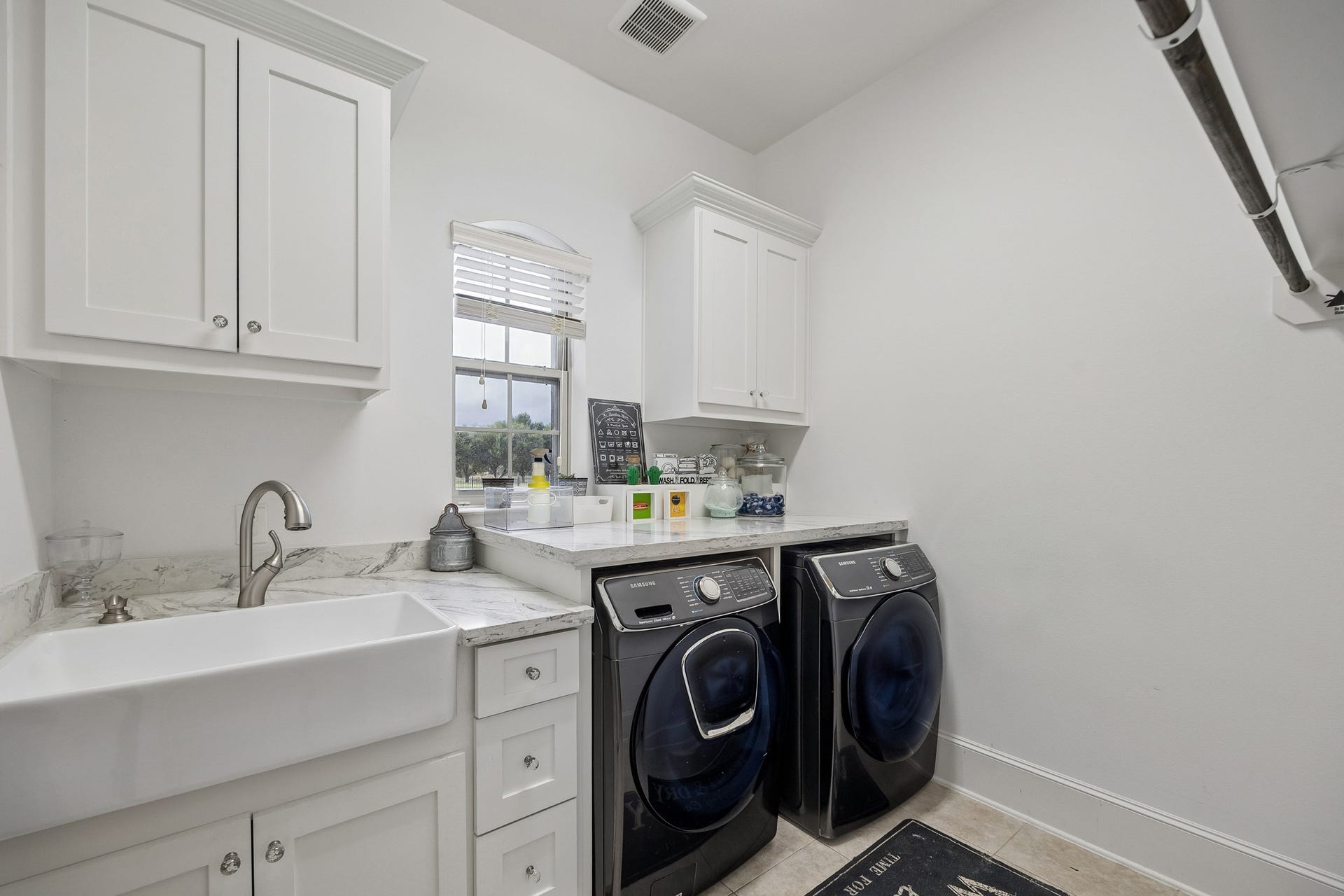 5018 Southampton Road, Missouri City, TX 77459 Bright and functional laundry room featuring, ample cabinetry, and a farmhouse sink for convenience.