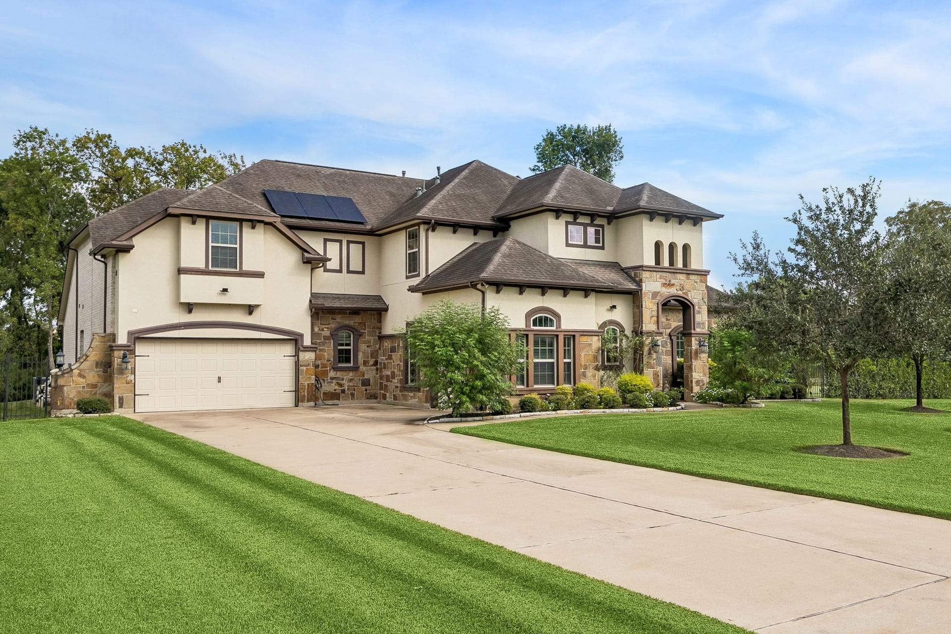 5018 Southampton Road, Missouri City, TX 77459 Elegant two-story home with a 3 car garage and spacious driveway, charming stone accents, and a manicured lawn, offering a perfect blend of modern amenities and classic style.