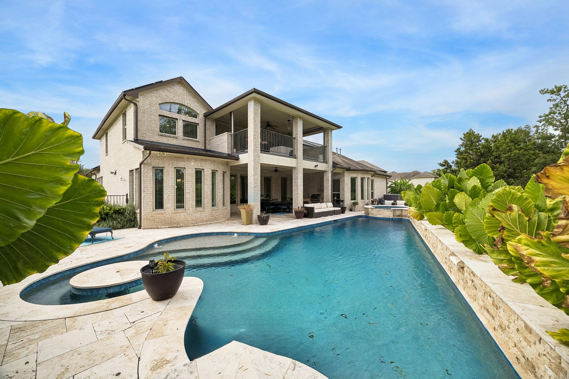 5018 Southampton Road, Missouri City, TX 77459 Stunning poolside oasis, expansive patio and balcony, and elegant stone accents, perfect for outdoor entertaining and relaxation.