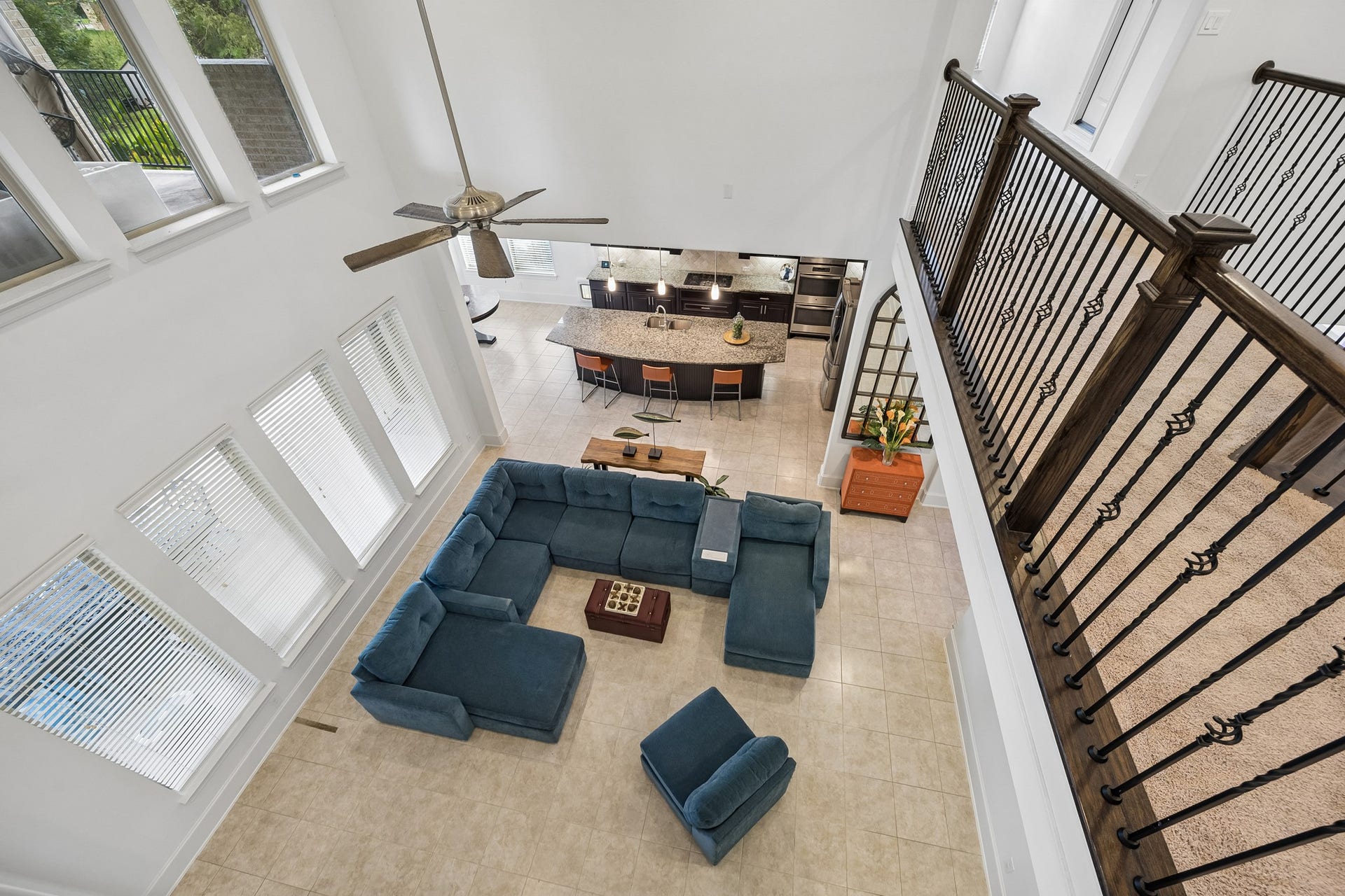 5018 Southampton Road, Missouri City, TX 77459 Spacious living area with high ceilings, abundant natural light from large windows. Overlooks a stylish kitchen with a large granite island and modern appliances.