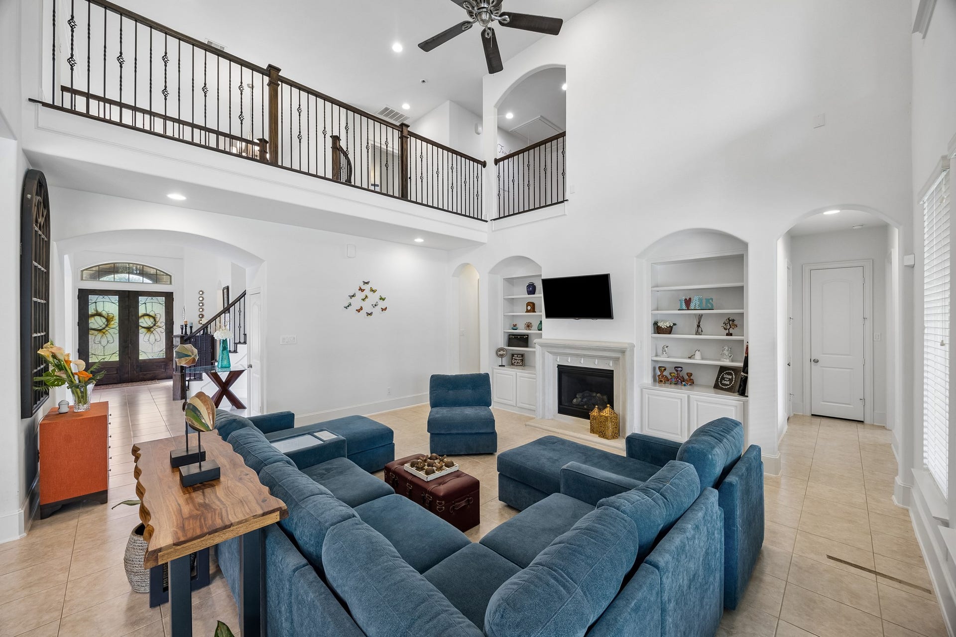 5018 Southampton Road, Missouri City, TX 77459 Spacious living room with high ceilings, elegant staircase, and an inviting gas log fireplace. The open layout flows seamlessly with ample natural light and tasteful built-ins.