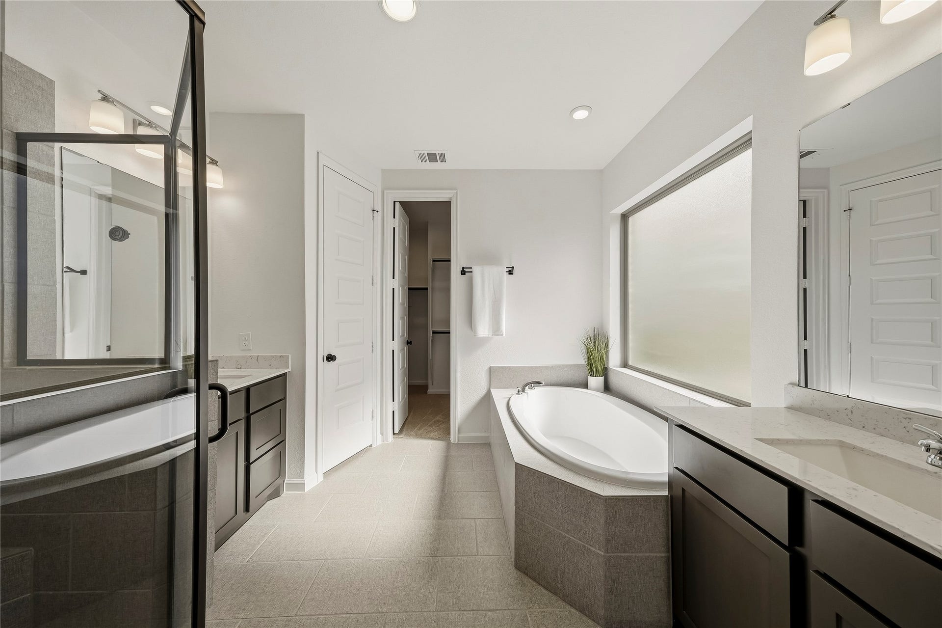 10606 Novy Grove Drive, Missouri City, TX 77459 The primary bath has dual vanities so everyone has plenty of elbow room to get ready in the morning! The garden tub has a large picture frame window, with privacy glass.