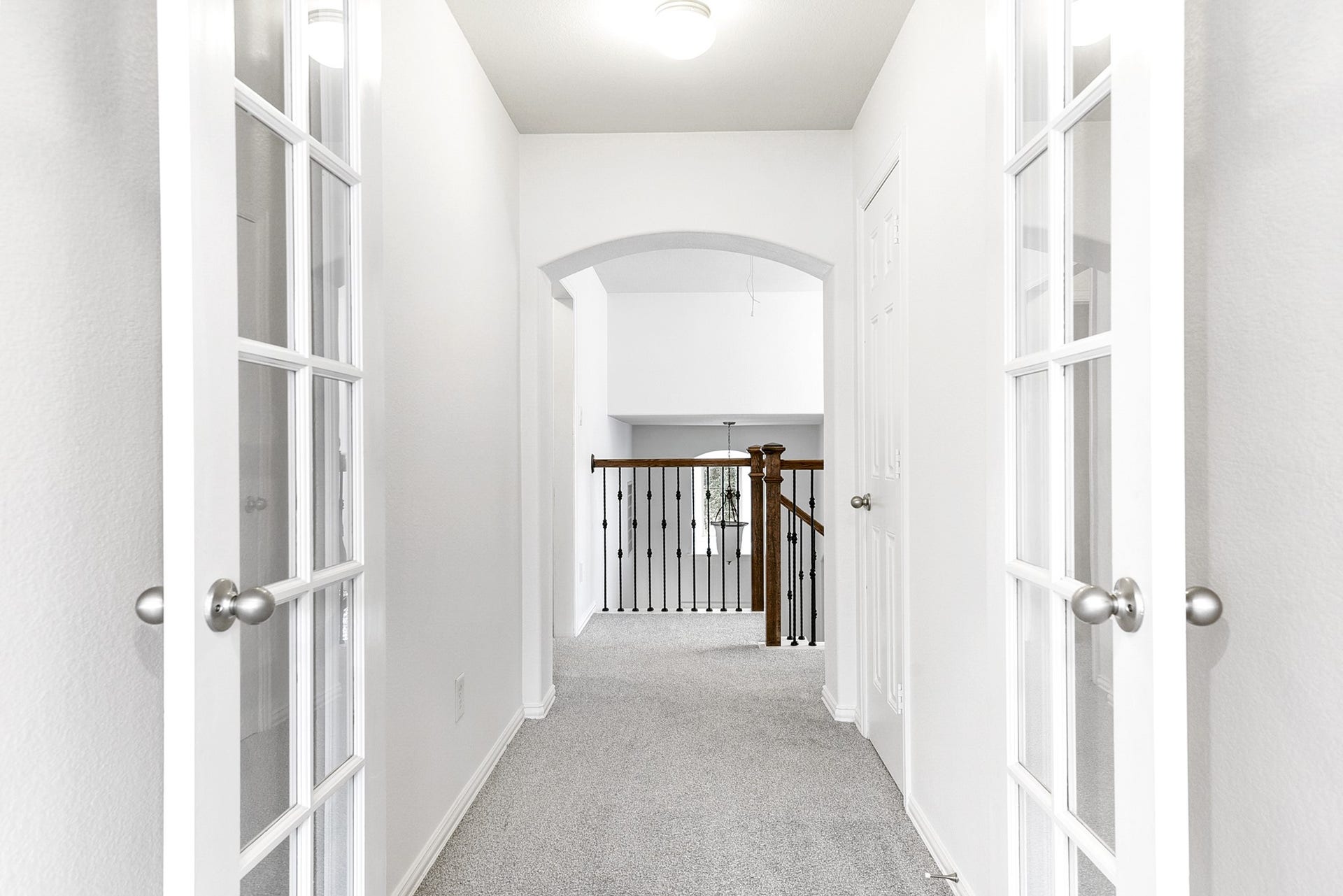 This is a view from the upstairs media room, looking out toward the staircase, providing a clear perspective of the homes layout and flow between levels.