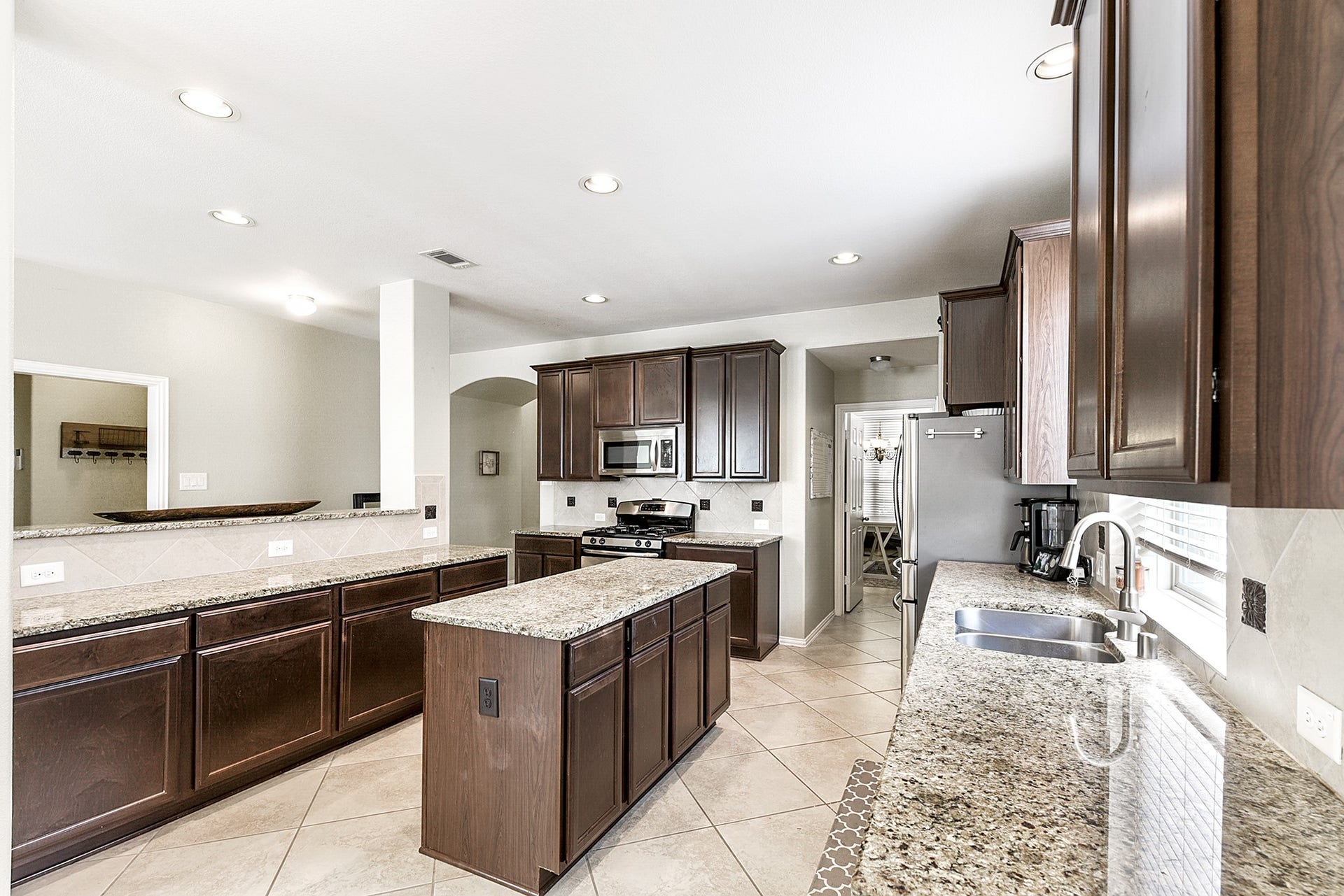 The kitchen features a large window above the sink, allowing natural light to illuminate the space and providing a pleasant view while working in the kitchen.