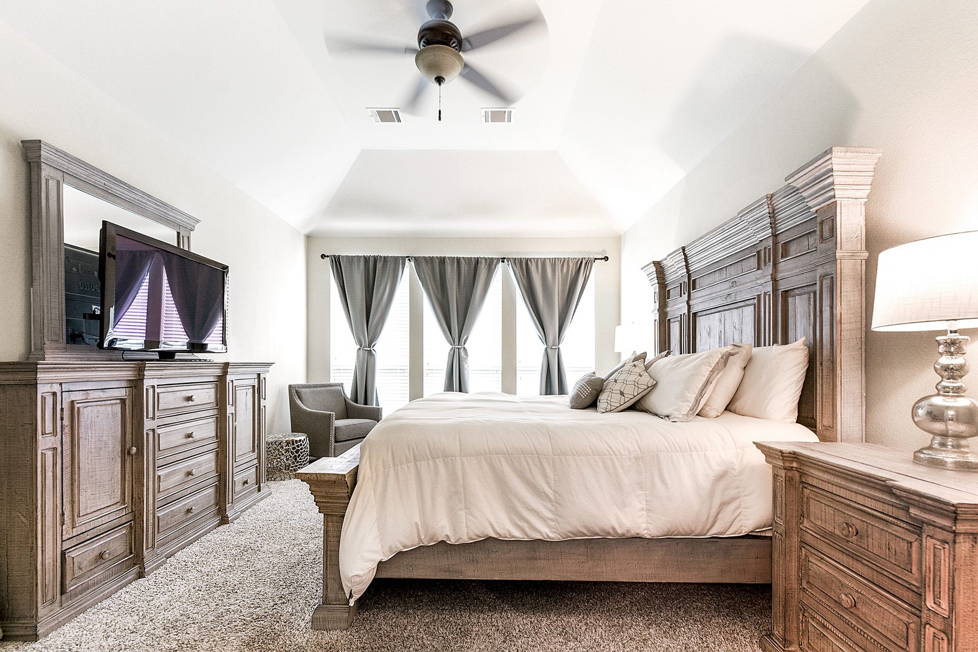 Another view showcases the spaciousness of this room, easily accommodating a king bedroom suite set and additional seating space, creating a luxurious retreat for relaxation and comfort.