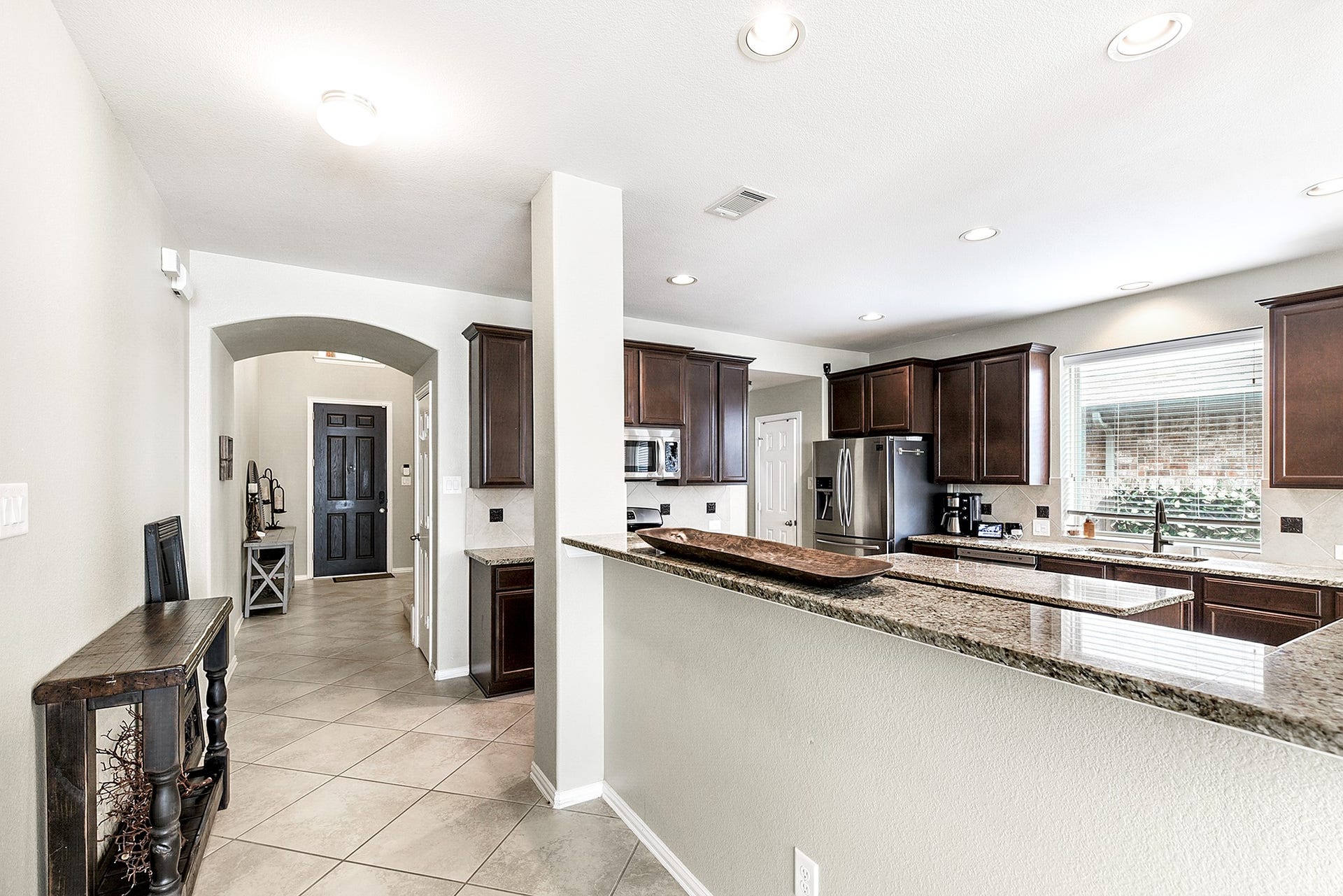 A view from the living room to the front door highlights the seamless flow, spaciousness, and openness of the home.