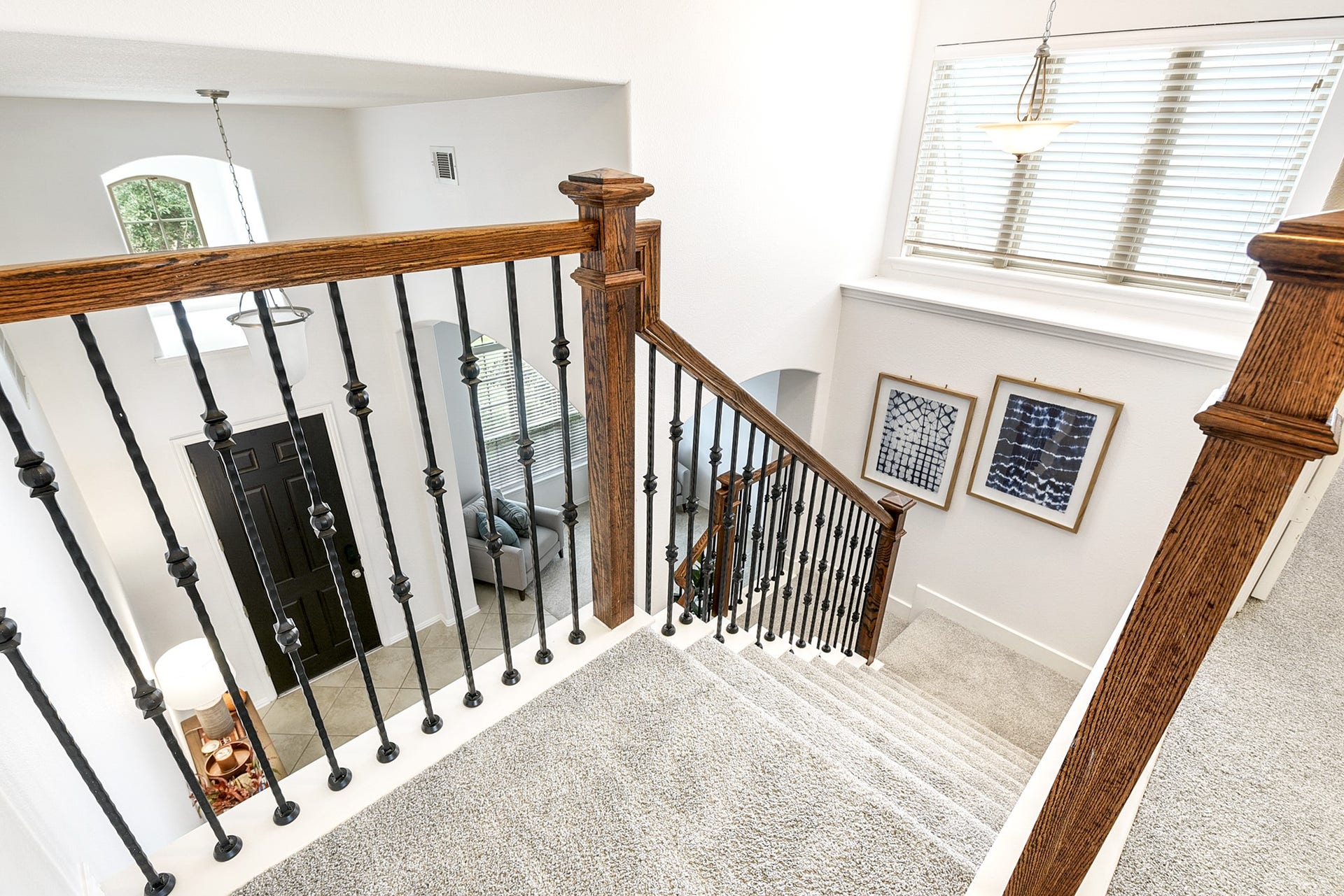 Another perspective shows the bottom of the stairs, along with views of the entryway and formal dining room.