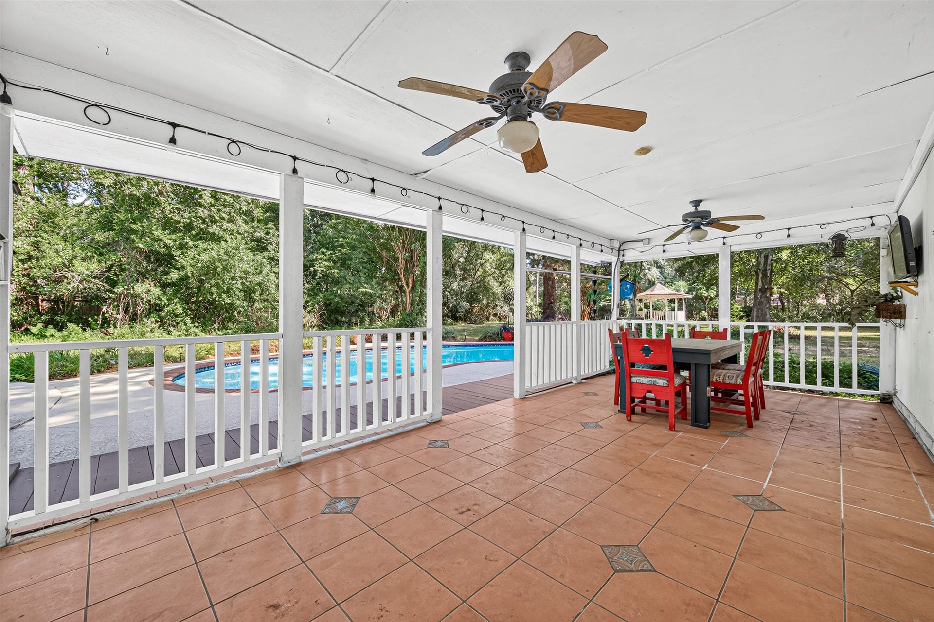 16814 Creeksouth Road, Houston, TX 77068 The covered patio has a terra cotta tile flooring, dual fans, outdoor tv, and surrounded with decorative lighting.