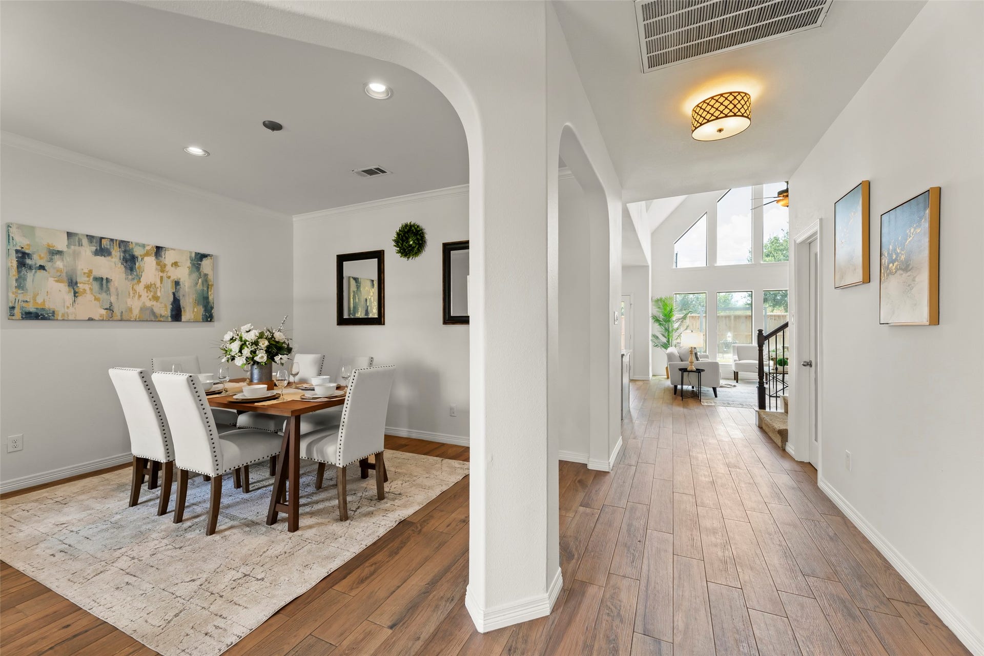 4534 Montcliff Bend Lane, Sugar Land, TX 77479 Elegant dining area with a modern table setting and tasteful decor, leading into a bright, open living space with high ceilings and large windows.