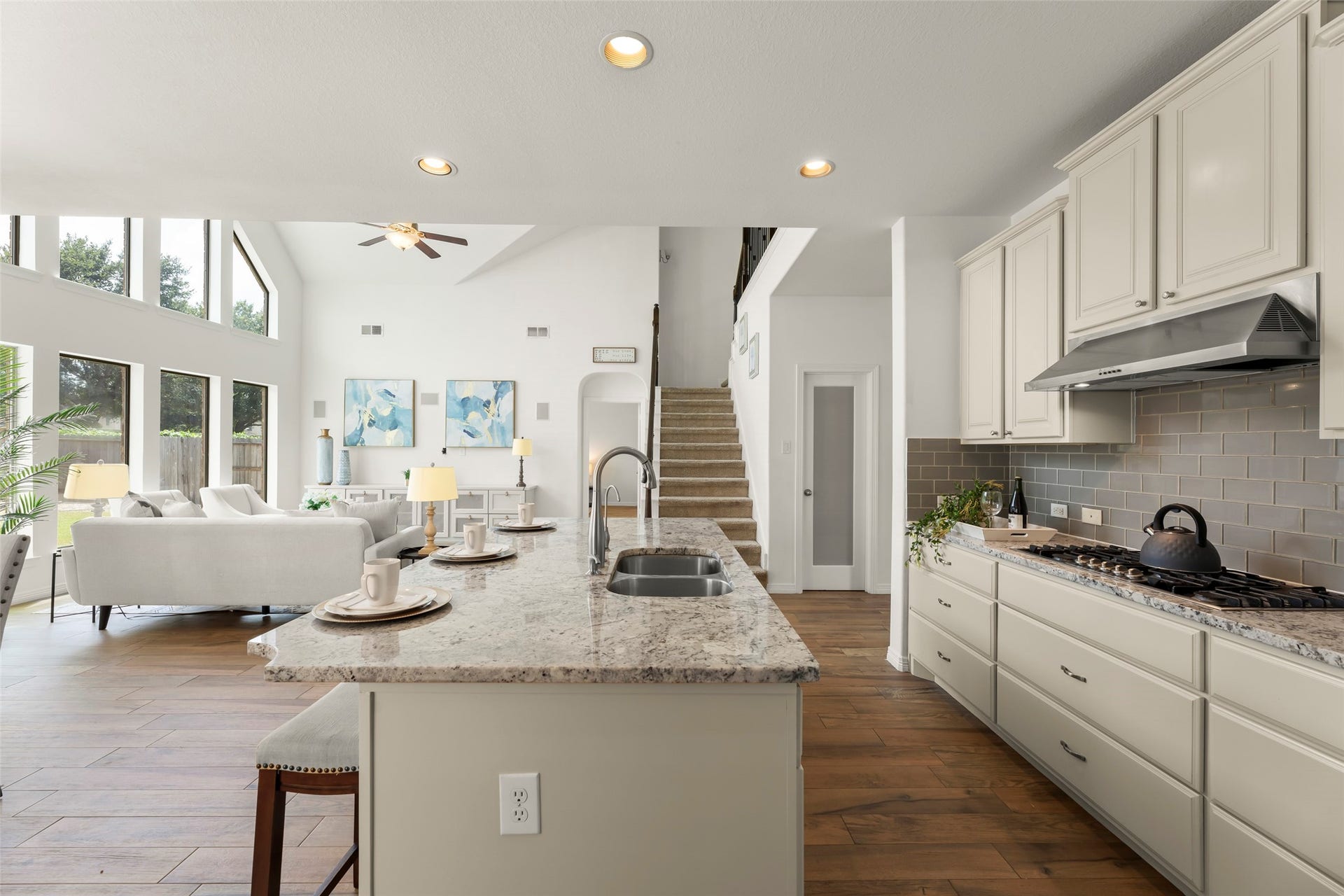 4534 Montcliff Bend Lane, Sugar Land, TX 77479 Modern elegance in this open-concept family room space, featuring a gourmet kitchen with granite countertops and stainless steel appliances, seamlessly flowing into a bright and airy living room with large windows and high ceilings.
