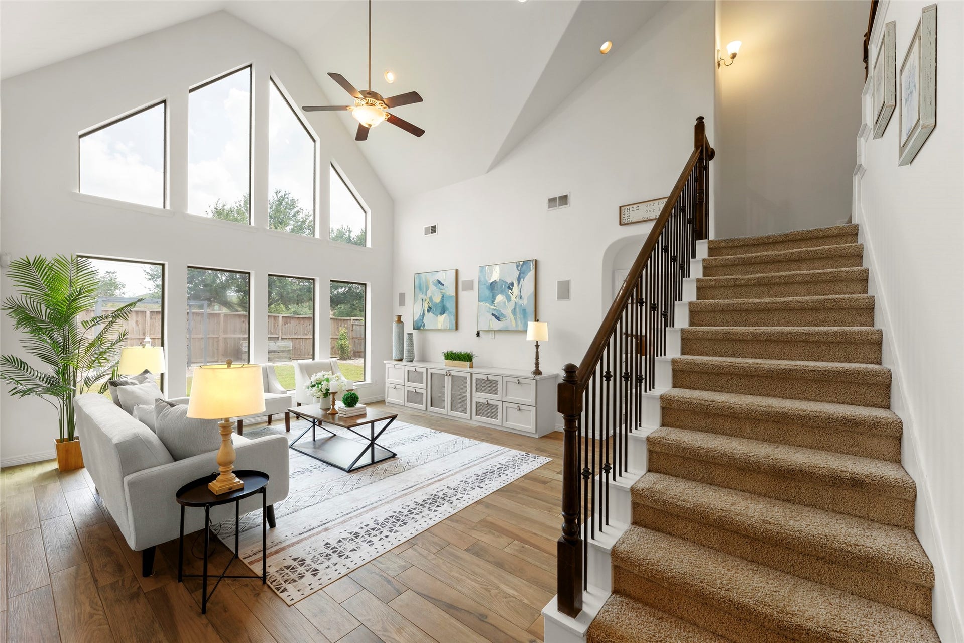 4534 Montcliff Bend Lane, Sugar Land, TX 77479 Open family room with soaring ceilings, large windows, and elegant staircase, offering a perfect blend of comfort and style.