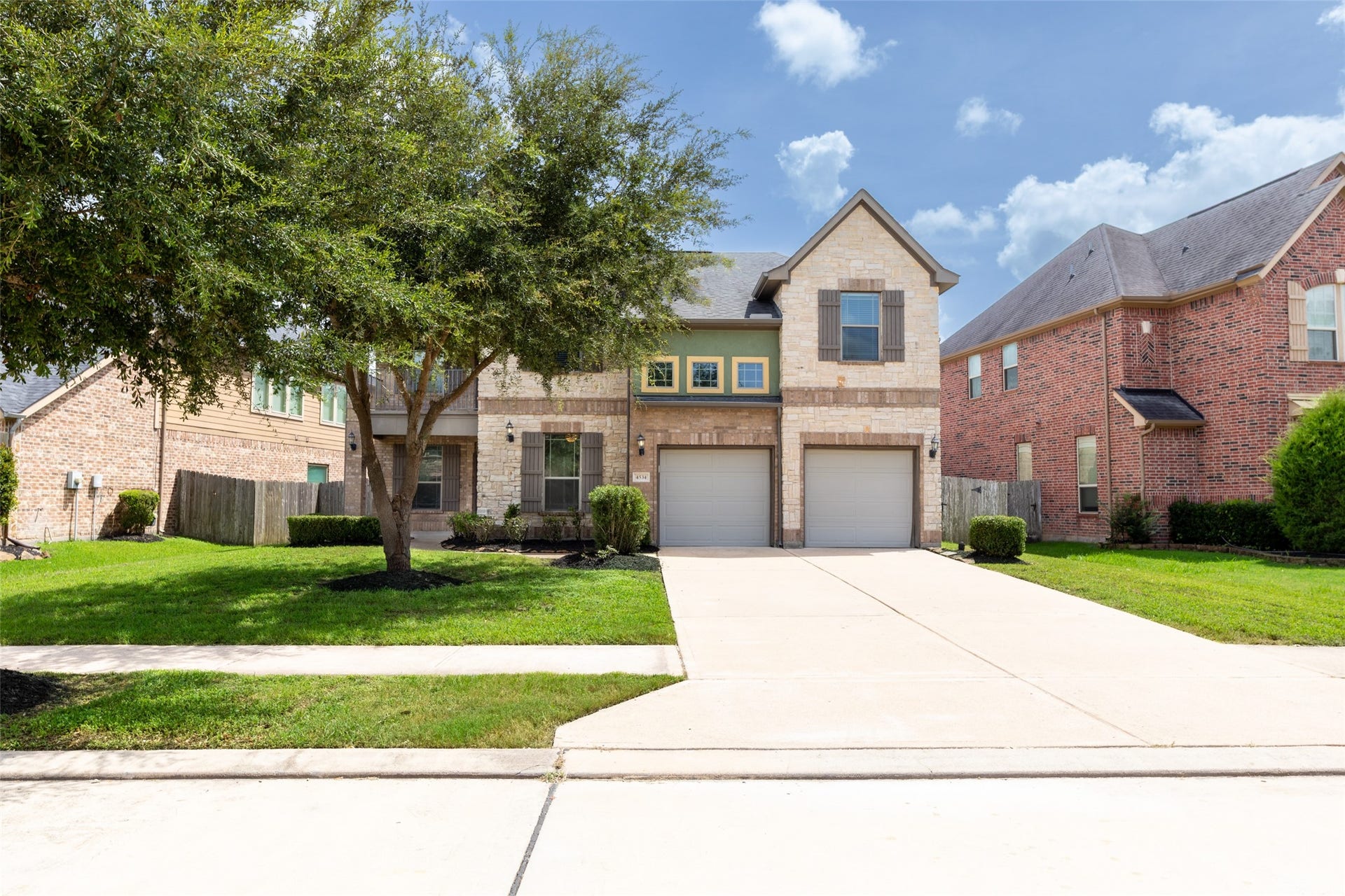 4534 Montcliff Bend Lane, Sugar Land, TX 77479 Long and wide driveway, dual garage, and inviting brick facade. Lush greenery and mature trees enhance curb appeal in a desirable neighborhood.