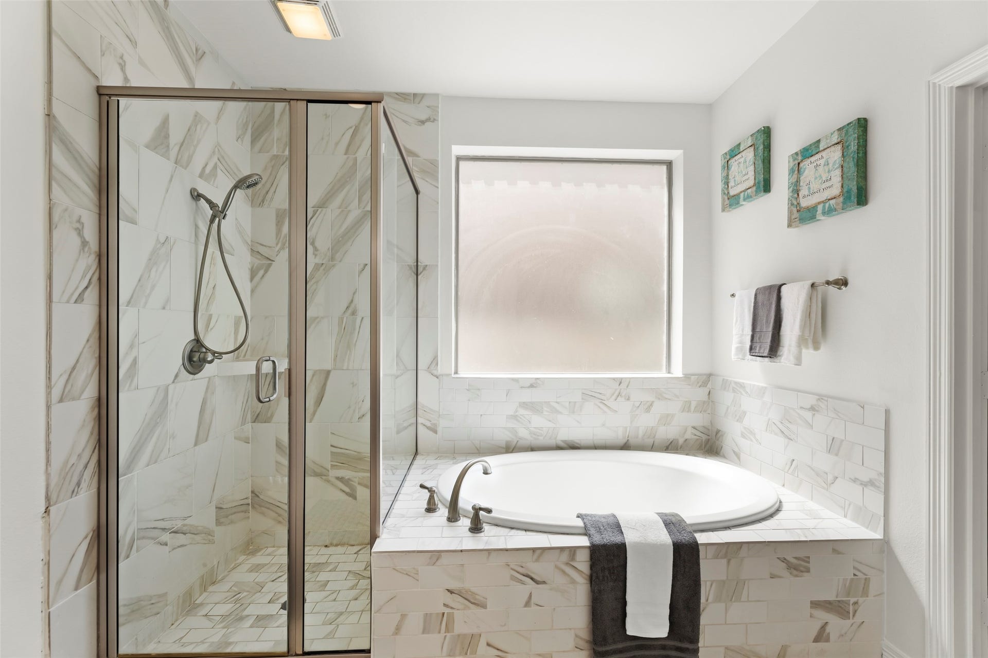 4534 Montcliff Bend Lane, Sugar Land, TX 77479 Luxurious spa-like bathroom featuring a sleek glass-enclosed shower and a relaxing soaking tub, accented with elegant tile work and natural light.
