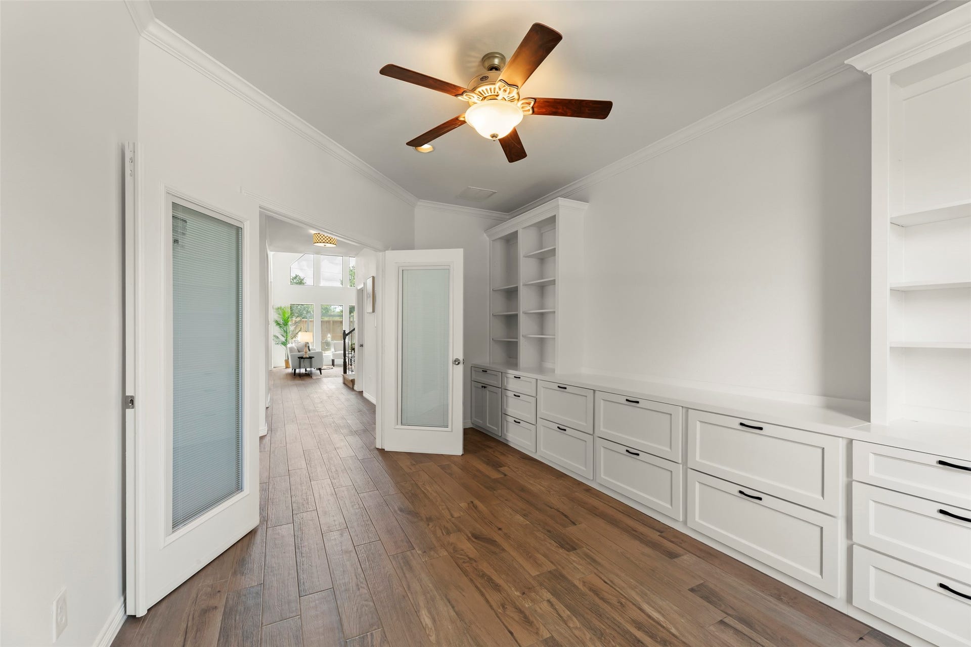 4534 Montcliff Bend Lane, Sugar Land, TX 77479 Beautiful hallway features custom built-in cabinetry and warm wood flooring, leading to a bright, inviting living space with abundant natural light.