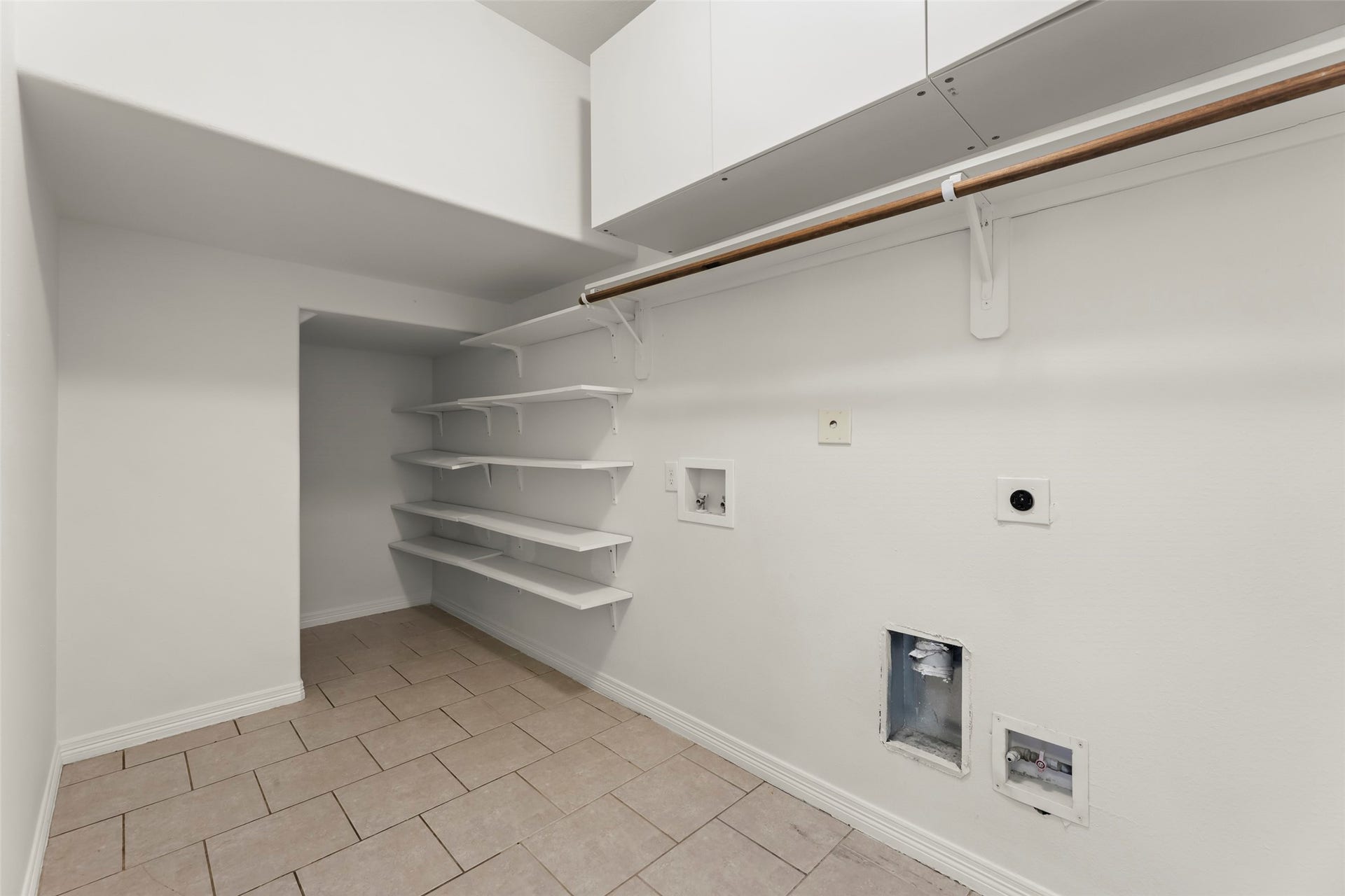 4534 Montcliff Bend Lane, Sugar Land, TX 77479 Great laundry room with ample shelving, utility connections, and tile flooring for easy maintenance.