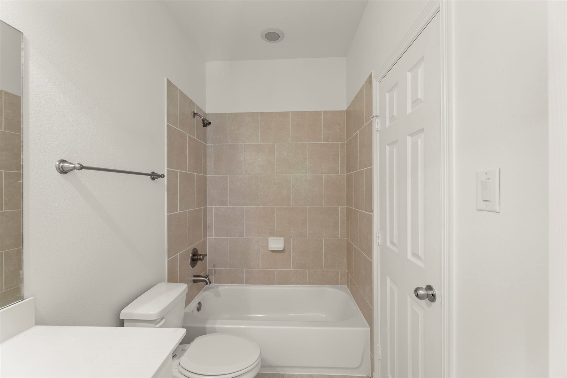 4534 Montcliff Bend Lane, Sugar Land, TX 77479 Lustrous bathtub with tiled walls, complemented by a clean white vanity and ample natural light.