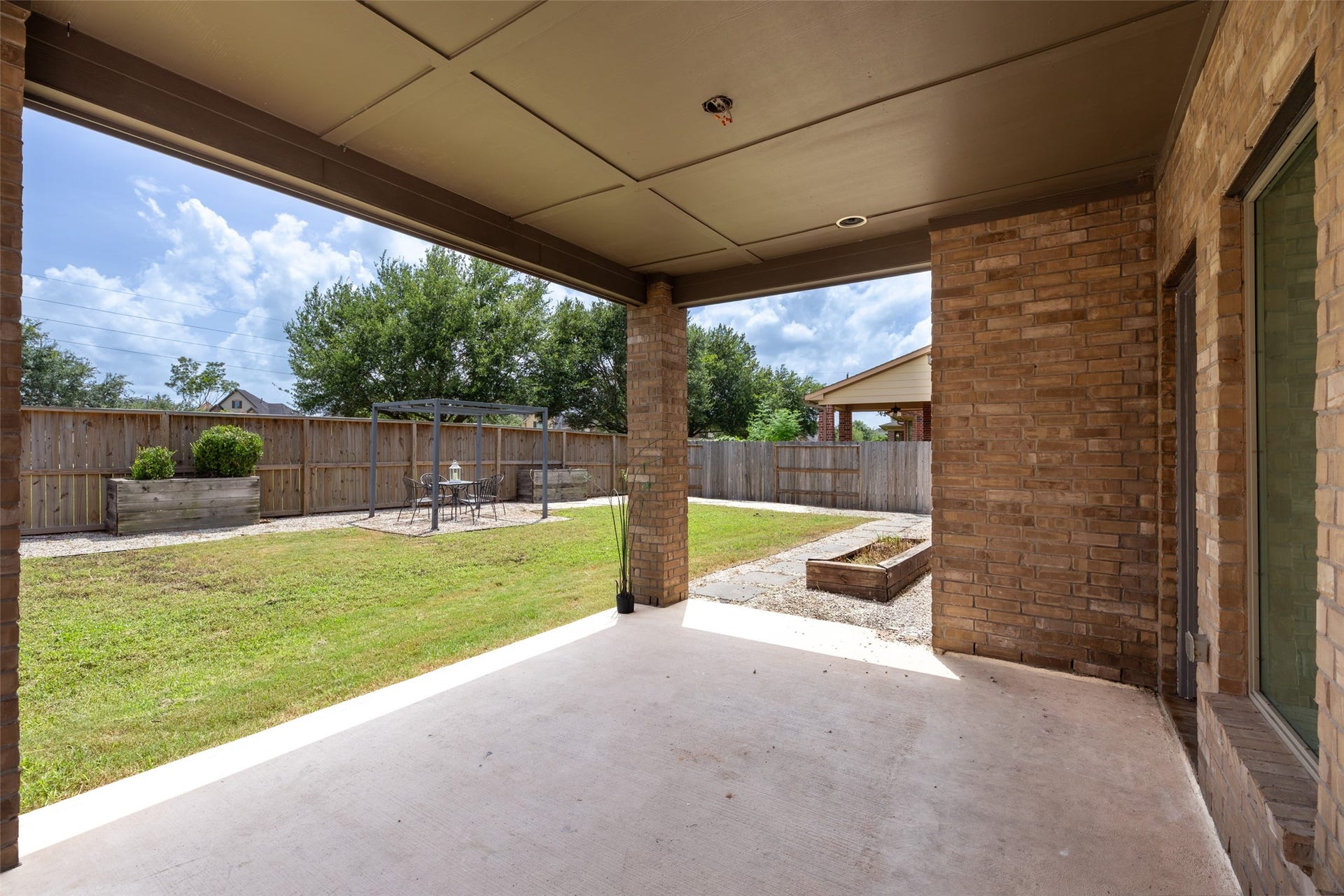 4534 Montcliff Bend Lane, Sugar Land, TX 77479 Voluminous covered patio overlooking a lush backyard, perfect for outdoor gatherings and relaxation.