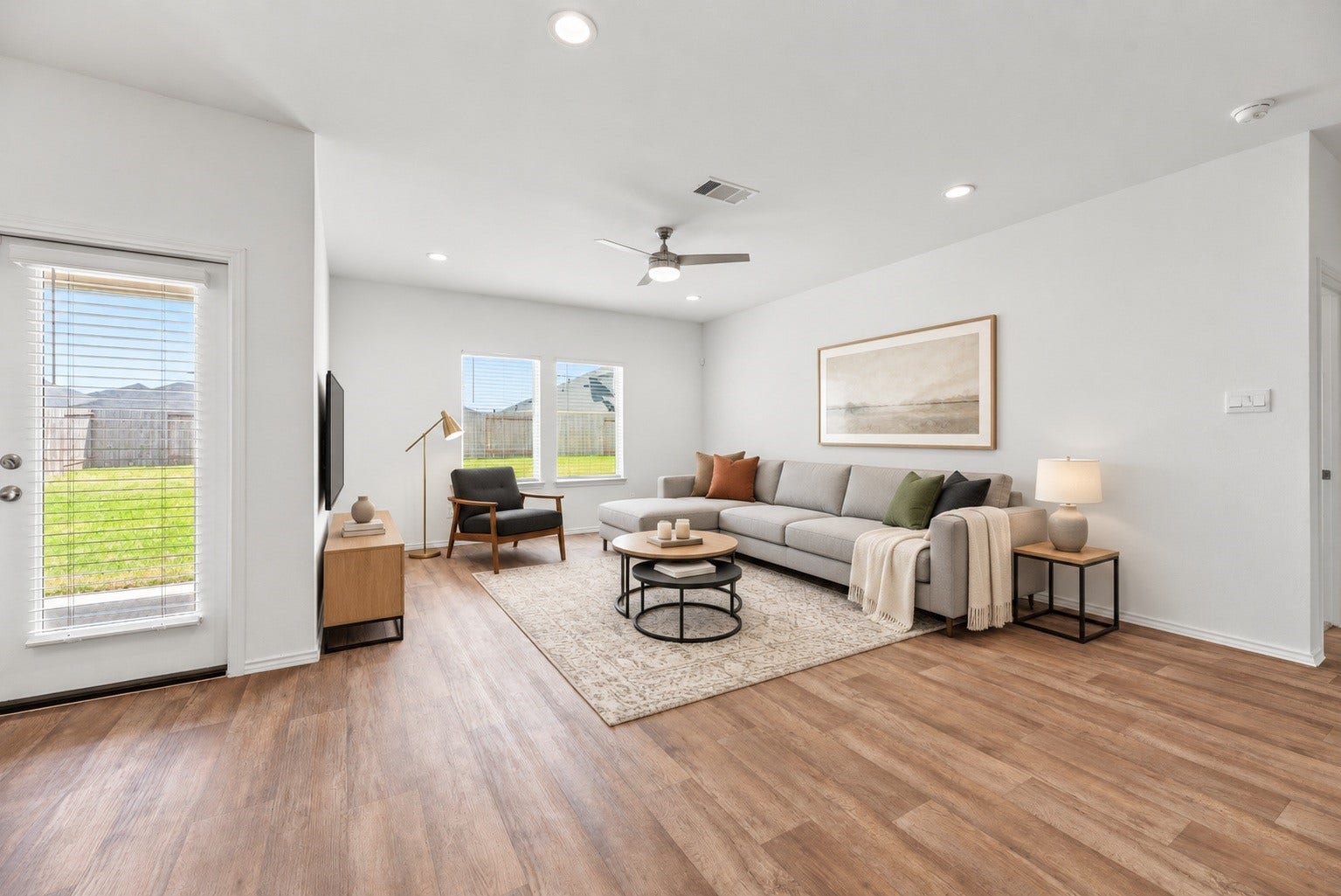 The living area features a cooling ceiling fan and large windows that fill the space with natural light while providing views of the private backyard. Virtually staged so you can imagine the possibilities.