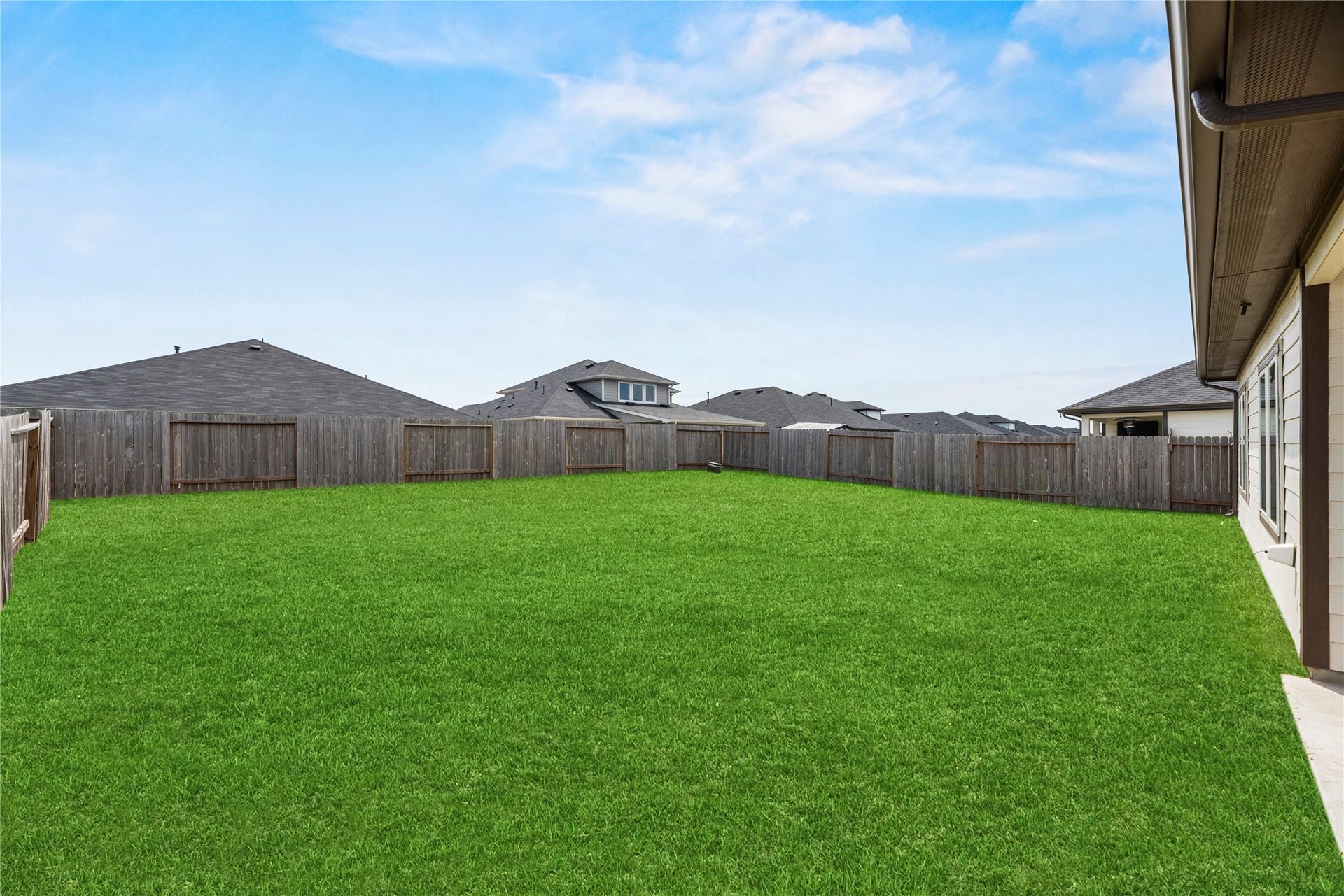 This expansive backyard is fully fenced for privacy and features a lush, pristine lawn. It serves as a perfect blank canvas, offering ample space for a future playground, custom landscaping, or your own outdoor retreat.