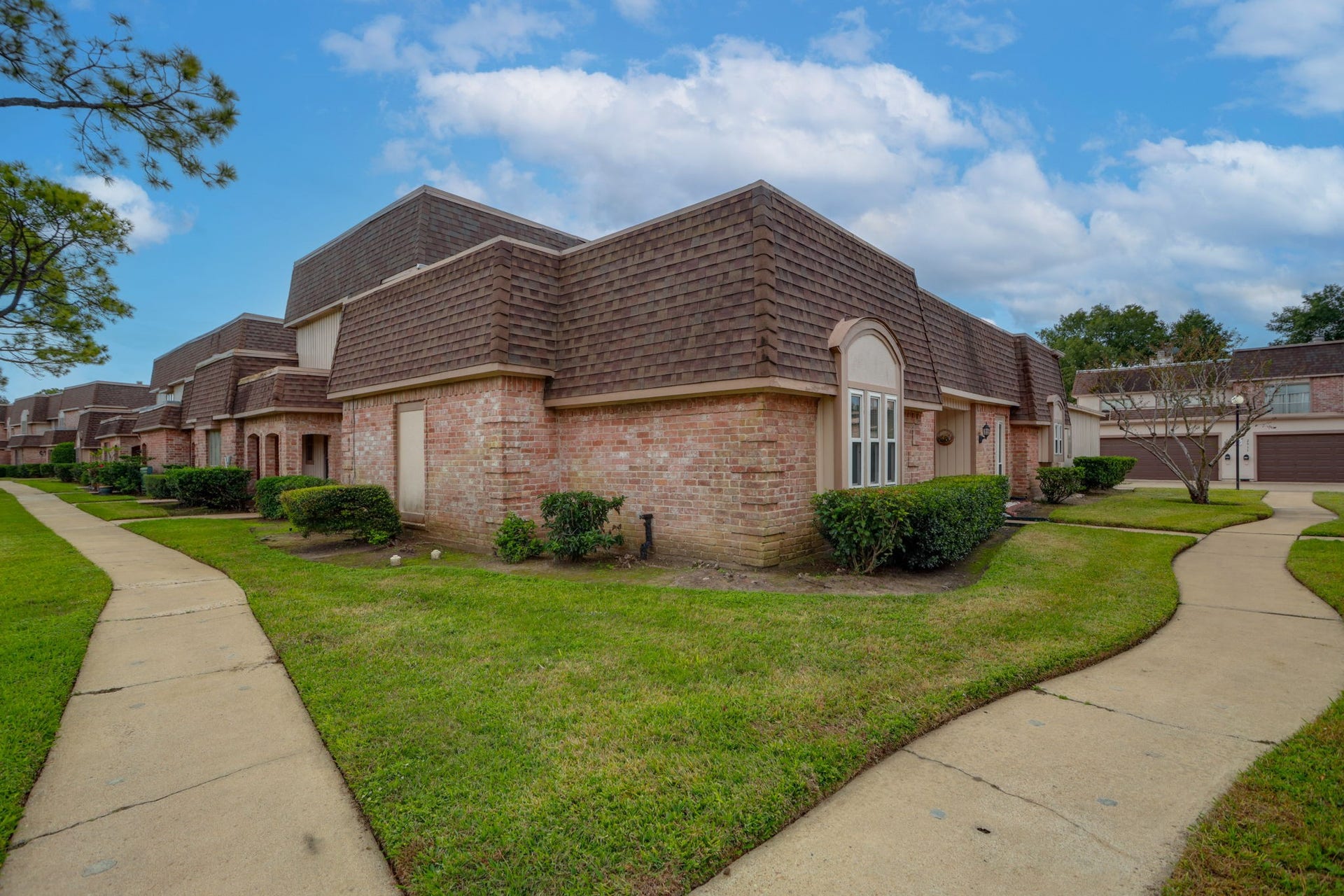 2912 Camelot Lane, Missouri City, TX 77459 Traditional brick faades, established landscaping, and connecting sidewalks give the Quail Valley townhome community a cohesive neighborhood setting. Green spaces frame the residences and pedestrian walkways. This exterior perspective places 2912 Camelot Lane within its Missouri City surroundings and highlights the communitys distinctive architectural style.