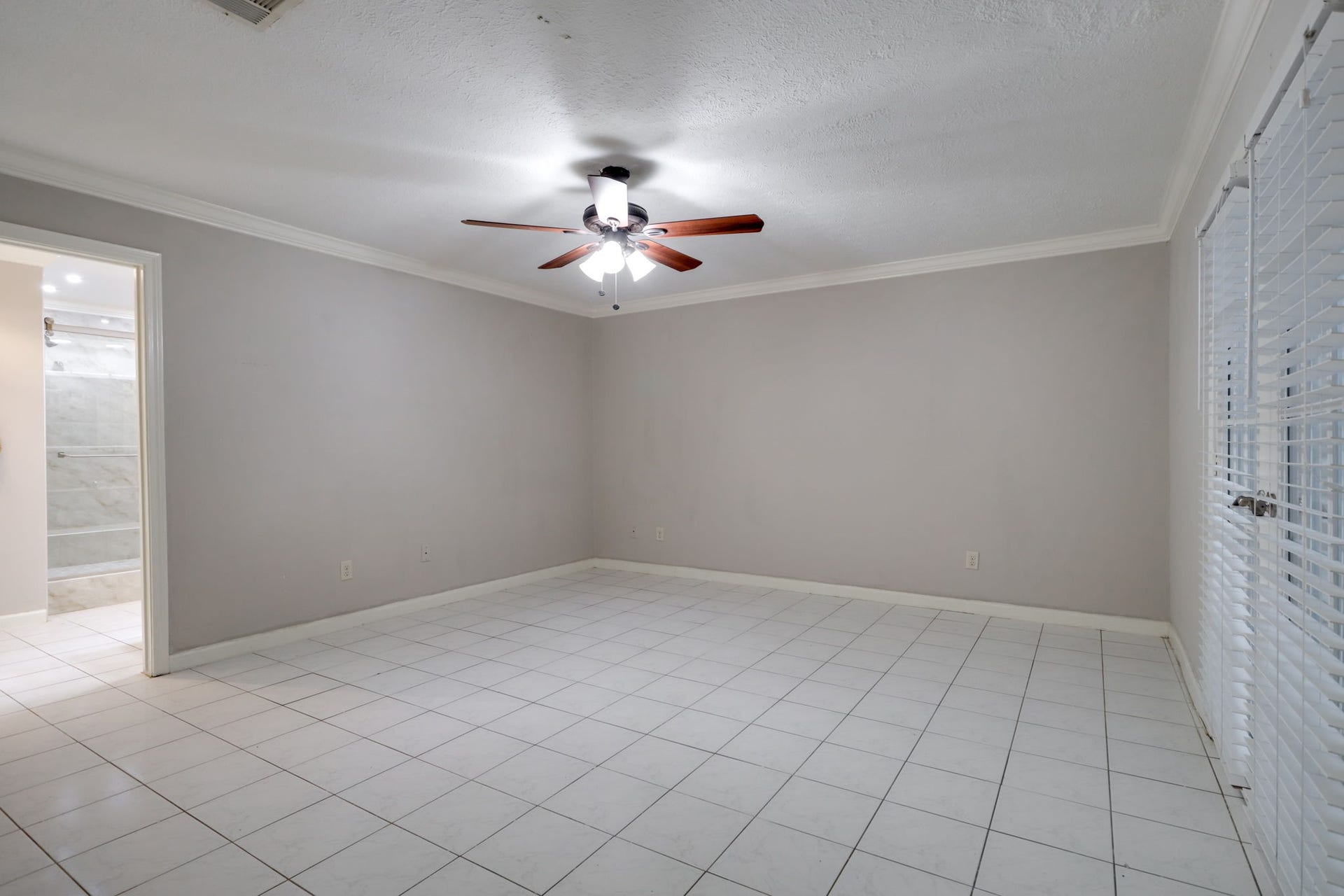 2912 Camelot Lane, Missouri City, TX 77459 The spacious primary bedroom offers a comfortable retreat with neutral walls, crown molding, and tile flooring. A ceiling fan provides an added comfort feature, while the rooms open floor space allows flexibility for arranging bedroom furnishings. Its single-story setting keeps the primary suite on the same level as the homes living spaces.