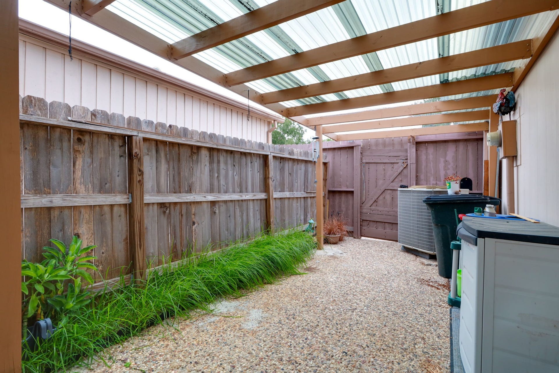 2912 Camelot Lane, Missouri City, TX 77459 Personalize this private fenced patio with outdoor seating, container plants, or a small garden arrangement. An overhead cover filters daylight across the textured paved surface, while a planting bed adds greenery along the fence. Gated access provides a convenient connection beyond this outdoor extension of the townhome.
