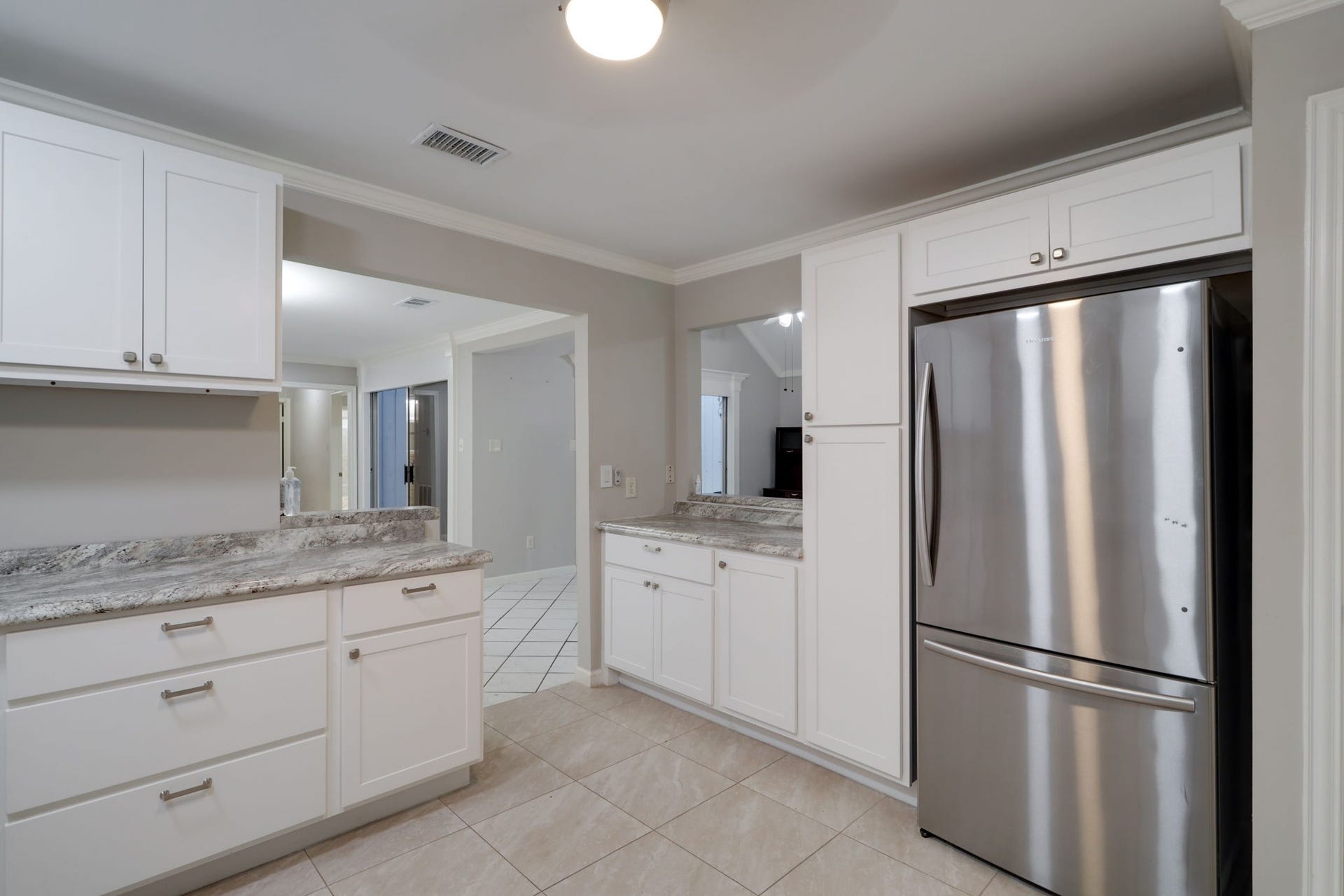 2912 Camelot Lane, Missouri City, TX 77459 White cabinetry surrounds the stainless steel refrigerator, making use of the kitchens storage space above and alongside the appliance. Additional counters offer room for meal preparation, small appliances, or a coffee station. The dining area sits just beyond the opening, keeping serving and gathering conveniently close.