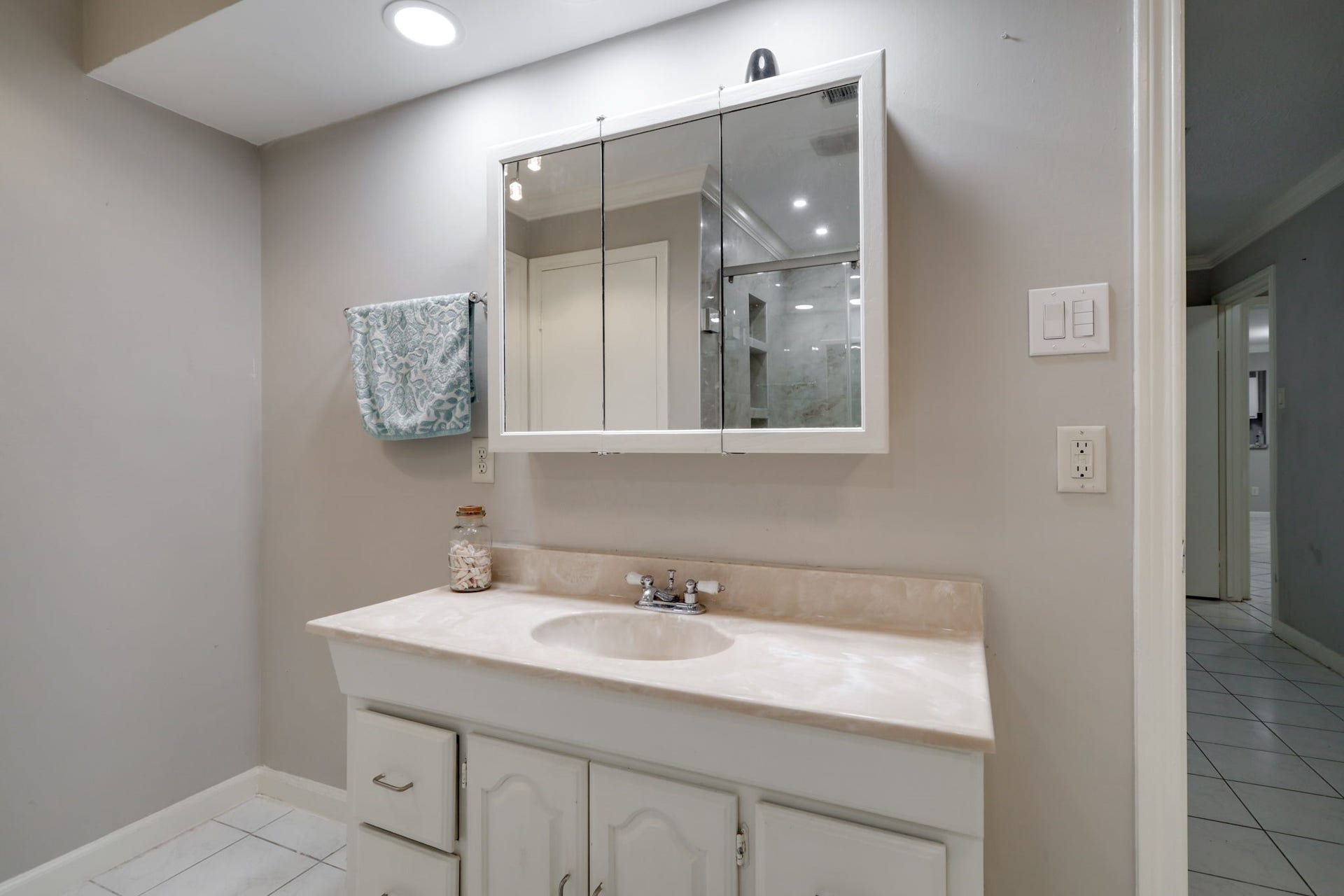 2912 Camelot Lane, Missouri City, TX 77459 The primary bathroom features a single-sink vanity with countertop space and cabinet storage below. A mirrored medicine cabinet adds convenient storage for daily essentials while keeping them within reach. Located directly off the primary bedroom, this dedicated bathroom supports a comfortable and practical suite layout.