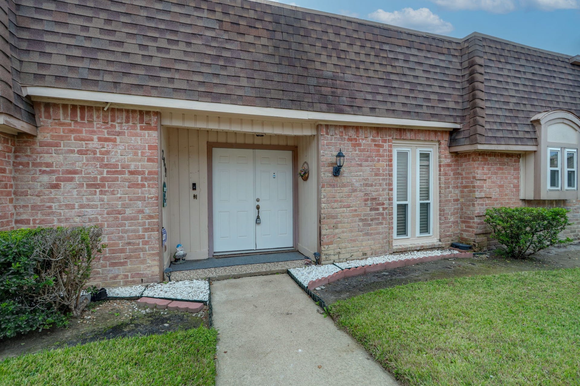 2912 Camelot Lane, Missouri City, TX 77459 A covered entrance and double front doors welcome you into this Quail Valley townhome. Traditional brickwork, decorative window trim, and planting beds give the exterior character, while the recessed entry provides a sheltered arrival. Beyond the doors, the floor plan opens toward the dining area and light-filled central atrium.