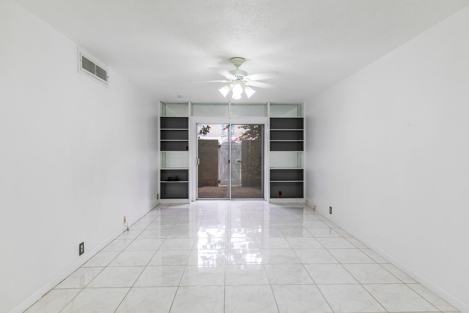 2601 Bellefontaine Street, #C104, Houston, TX 77025 Main living room bright with shelves and opens to a beautiful courtyard