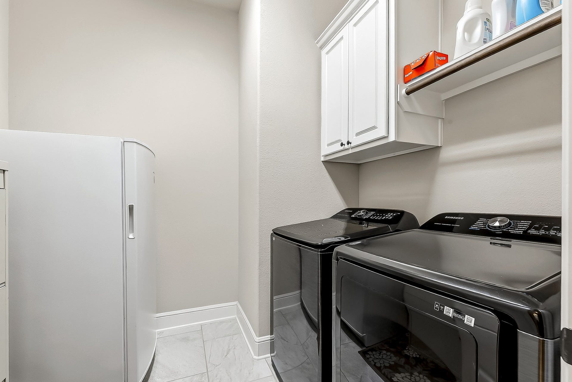 27411 Gladway Manor Drive, Katy, TX 77494 The spacious utility room offers plenty of room for an additional refrigerator or freezer, along with ample cabinetry, hanging rods, and built-in shelving for convenient storage and organization.