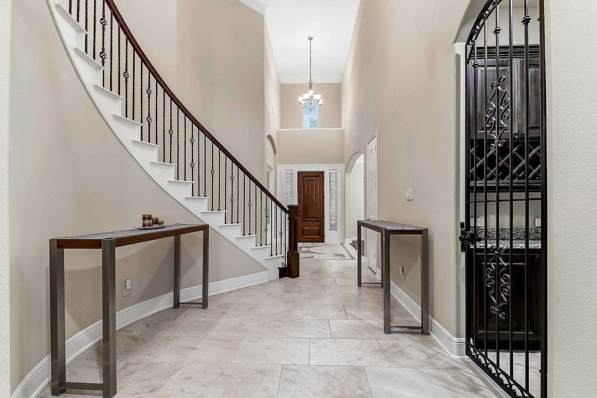 27411 Gladway Manor Drive, Katy, TX 77494 As you step into the grand foyer, youre greeted by soaring two-story ceilings and plenty of space for a seating area. From this view, the French-door home office is to the left, while the formal dining room is to the right, followed by a convenient hall closet. A beautiful wrought-iron gate opens to the wine grotto. Both the home office and formal dining room offer lovely views of the front yard.