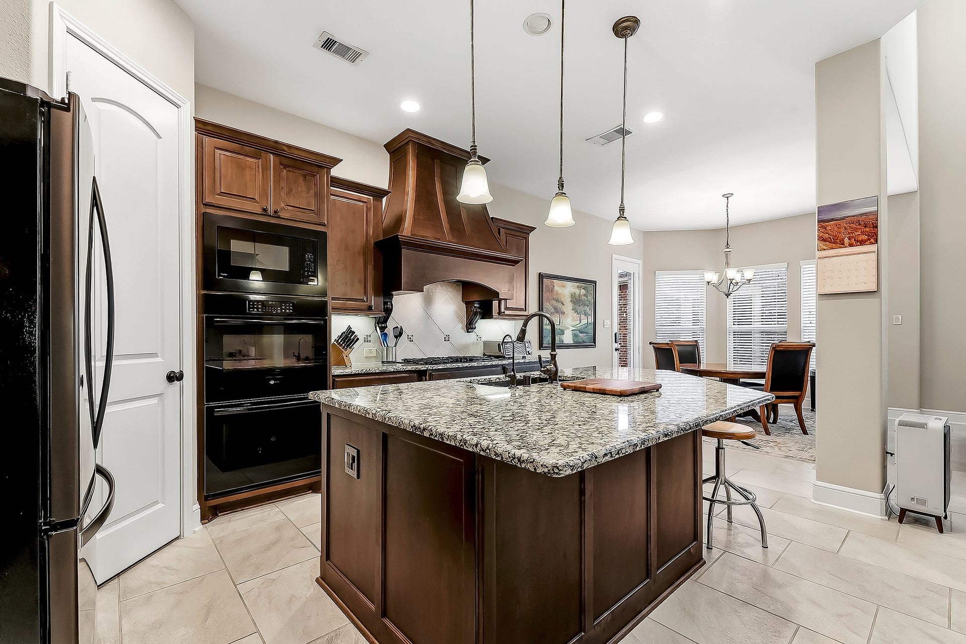 27411 Gladway Manor Drive, Katy, TX 77494 Rich cabinetry with convenient pull handles and expansive granite countertops provide both functionality and timeless elegance. The spacious walk-in pantry offers floor-to-ceiling storage, while the kitchen provides an abundance of cabinet and countertop space for effortless organization and meal preparation. Built-in appliances add to the streamlined design, including a double wall oven for added convenience when cooking and entertaining.