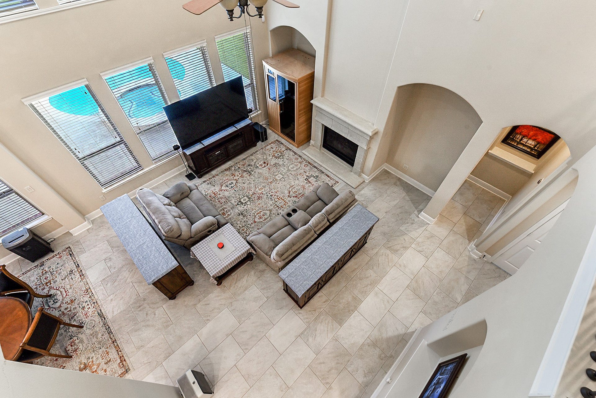 27411 Gladway Manor Drive, Katy, TX 77494 An aerial view overlooks the spacious living room, offering beautiful views into the breakfast room and out to the backyard pool. This perspective highlights the open flow between the main living spaces and the inviting outdoor oasis.