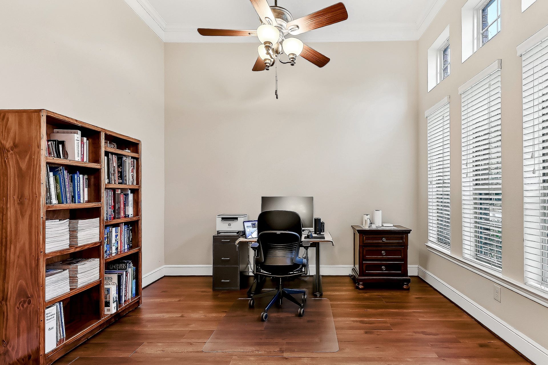 27411 Gladway Manor Drive, Katy, TX 77494 A closer look at the private home office reveals beautiful engineered hardwood flooring, crown molding, and high ceilings with a drop-down ceiling fan. A full wall of windows fills the space with natural light and offers beautiful front-yard views.