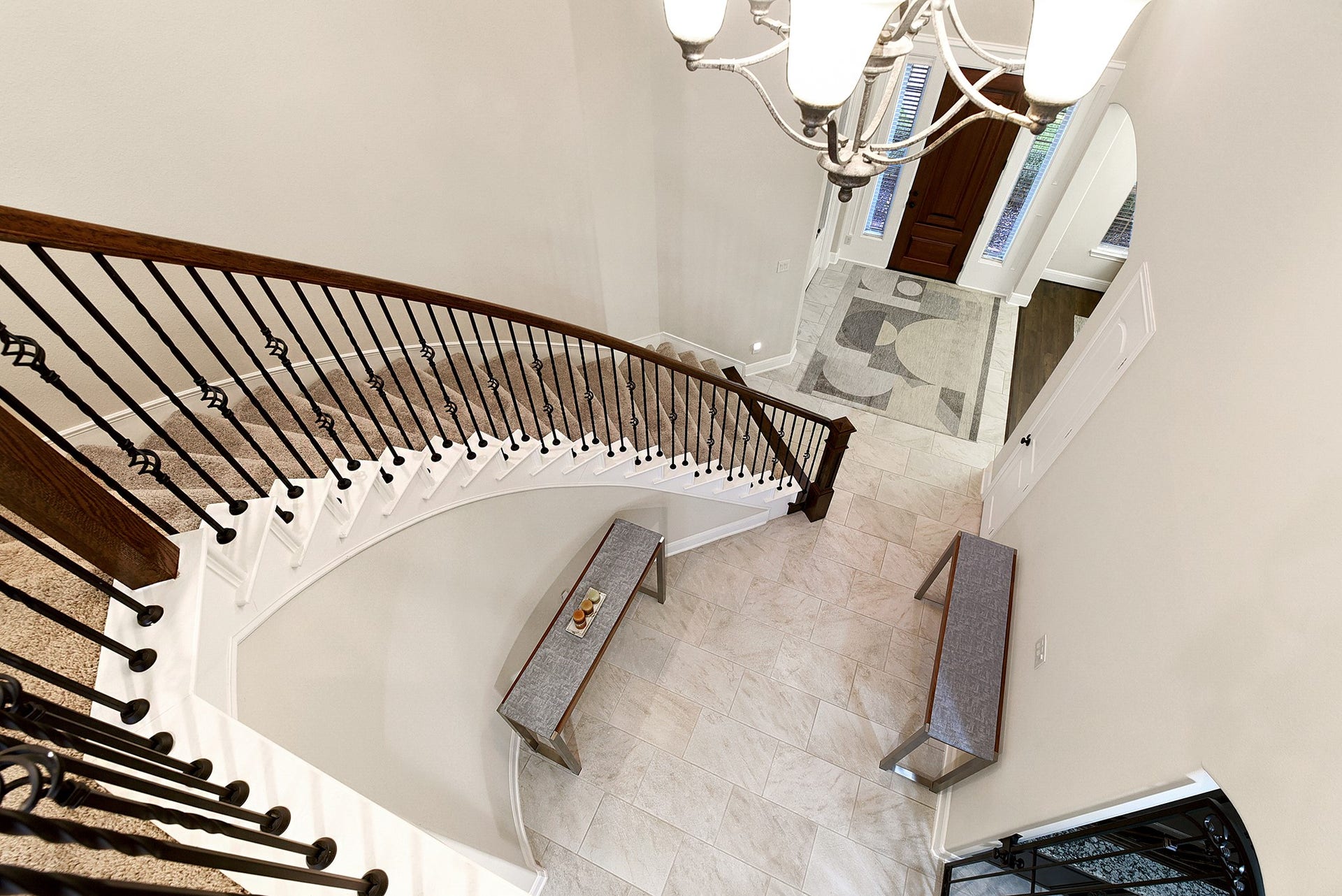 27411 Gladway Manor Drive, Katy, TX 77494 An aerial view overlooks the grand foyer and front entry, showcasing the elegant wrought-iron spiral staircase as a striking architectural focal point. The elevated perspective highlights the spacious foyer and beautiful flow of the home.