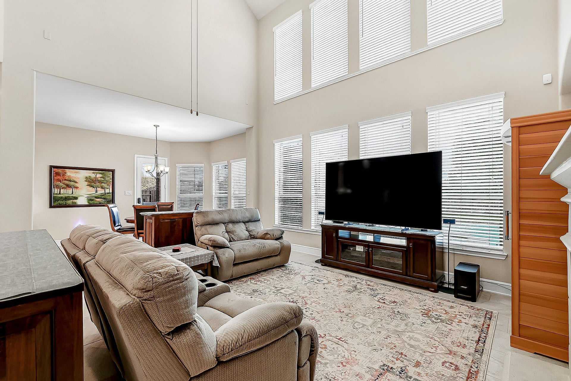 27411 Gladway Manor Drive, Katy, TX 77494 The same tile flooring continues throughout the downstairs, creating a seamless flow throughout the home. Eight large windows fill the space with natural light while offering beautiful views of the backyard, covered patio, pool, and spa, along with views into the breakfast room and kitchen.