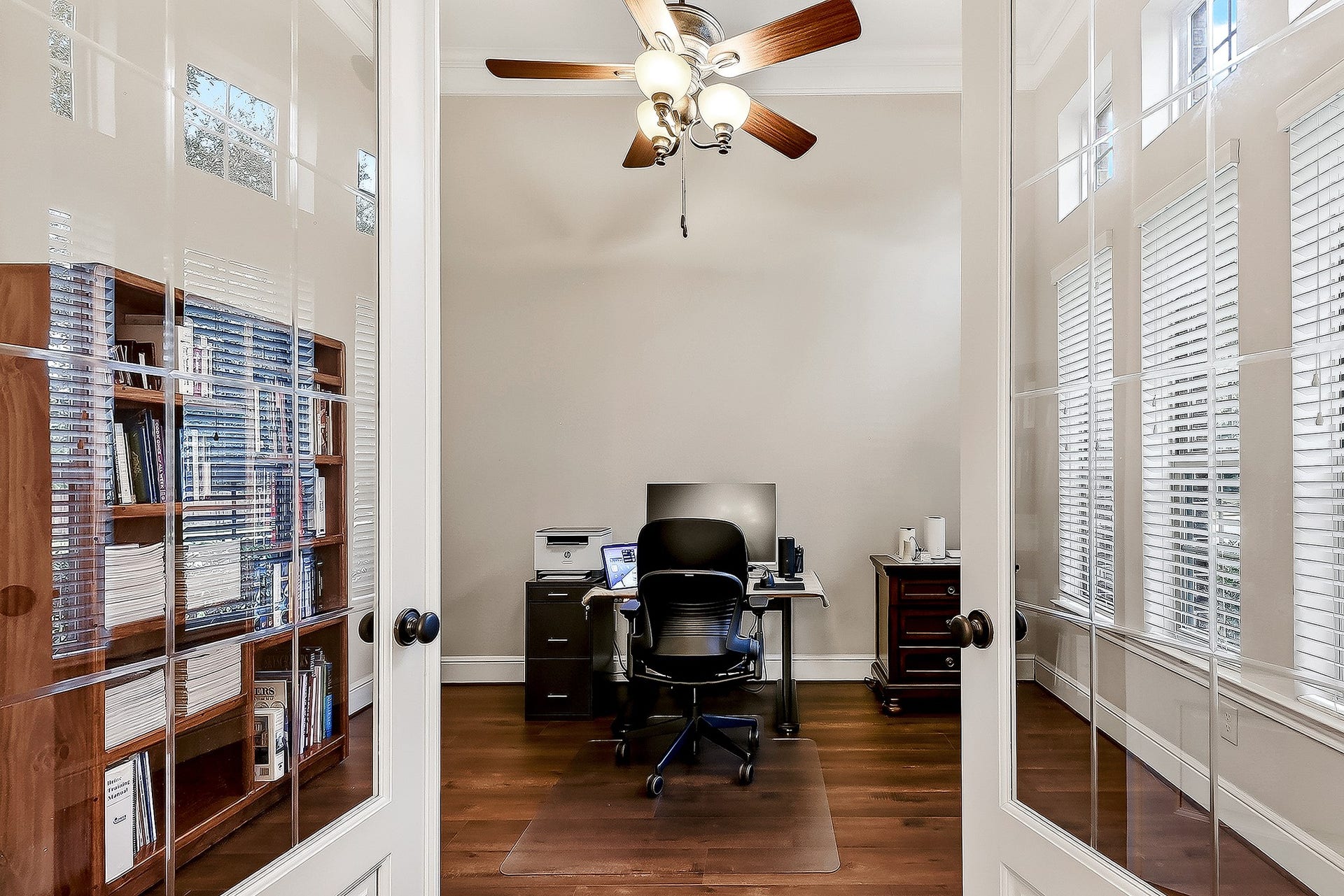 27411 Gladway Manor Drive, Katy, TX 77494 French doors lead into the private home office, featuring the same engineered hardwood flooring as the formal dining room. A wall of six windows fills the space with natural light and provides beautiful views of the front yard.
